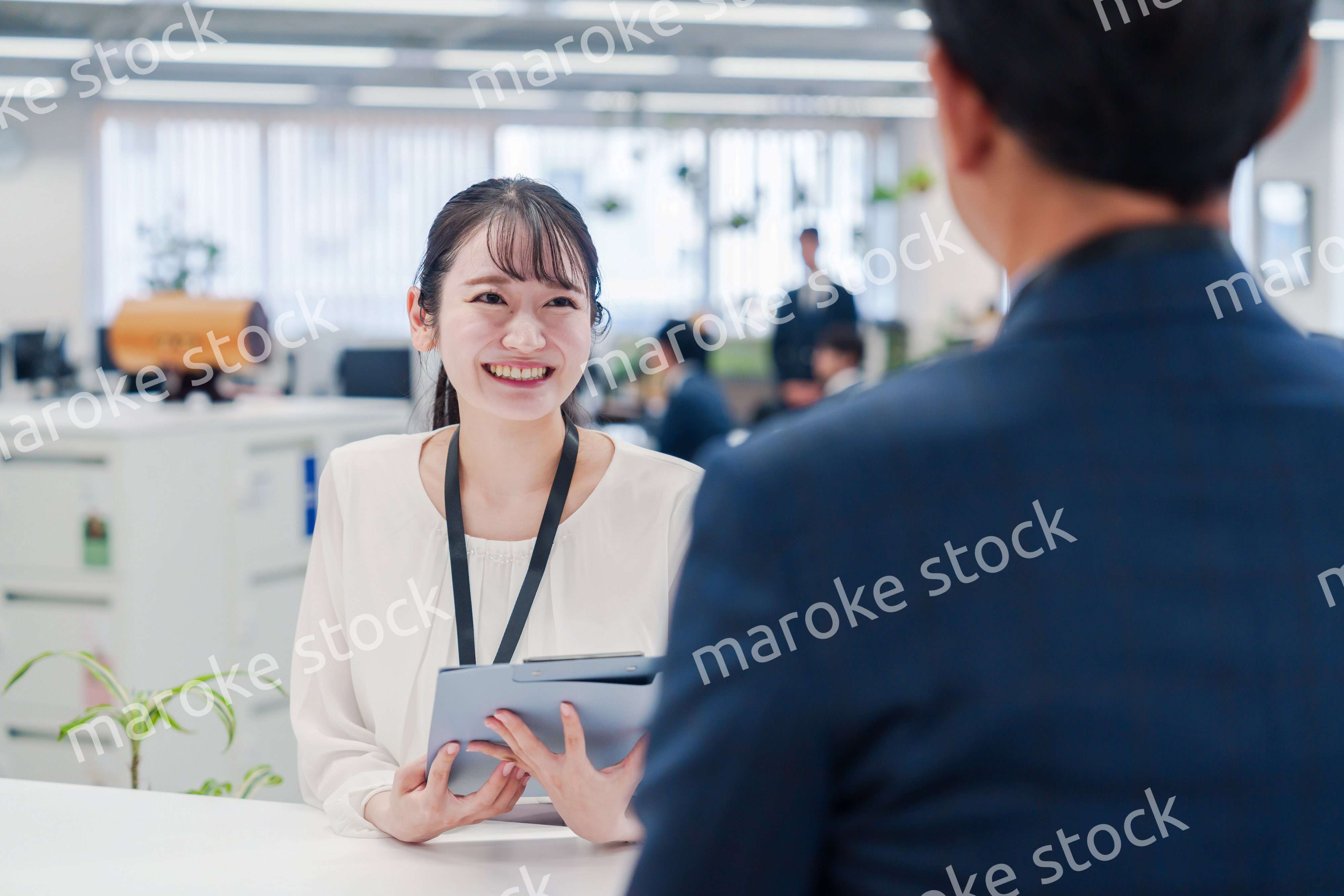 窓口で来客の対応をする女性スタッフ