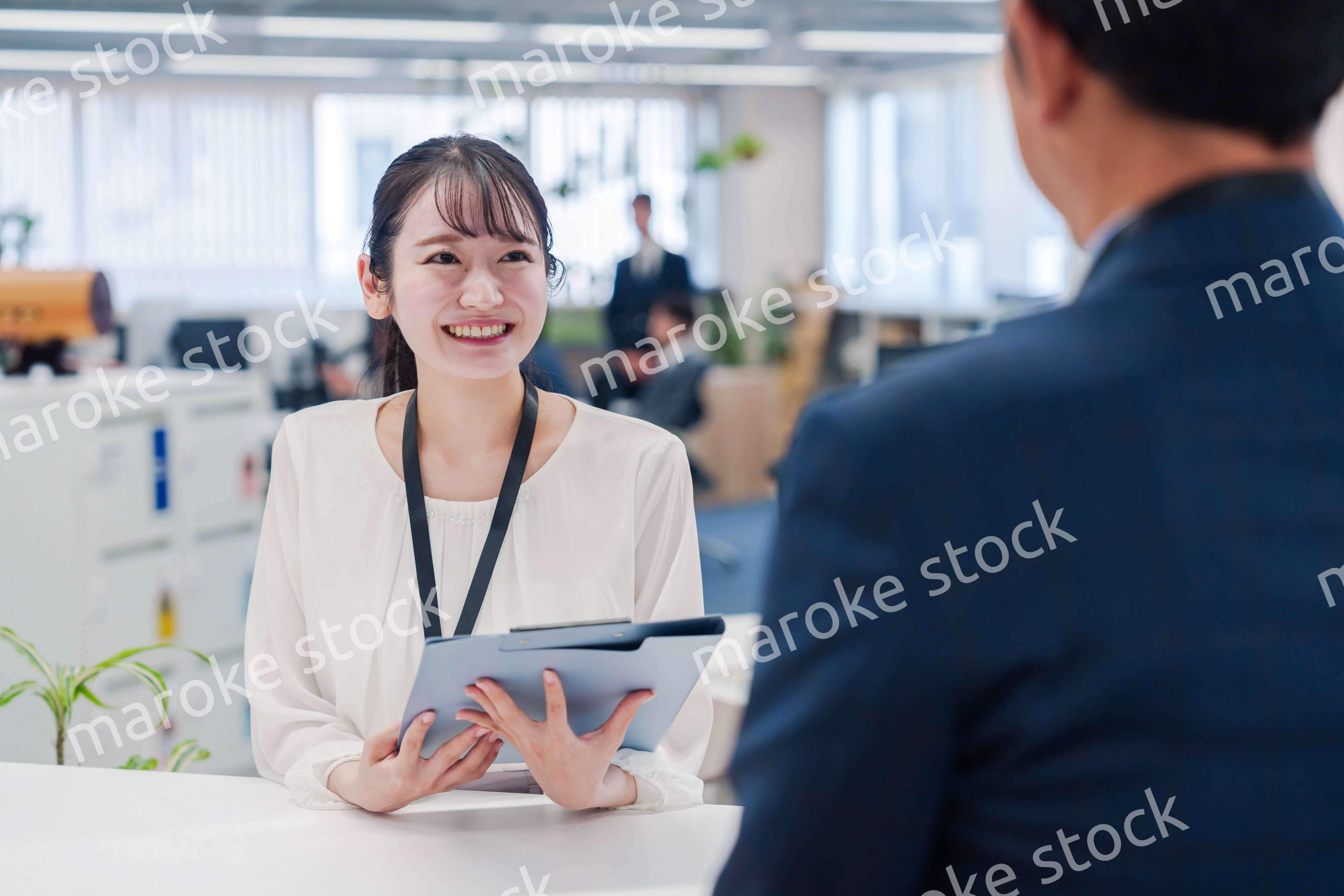 窓口で来客の対応をする女性スタッフ