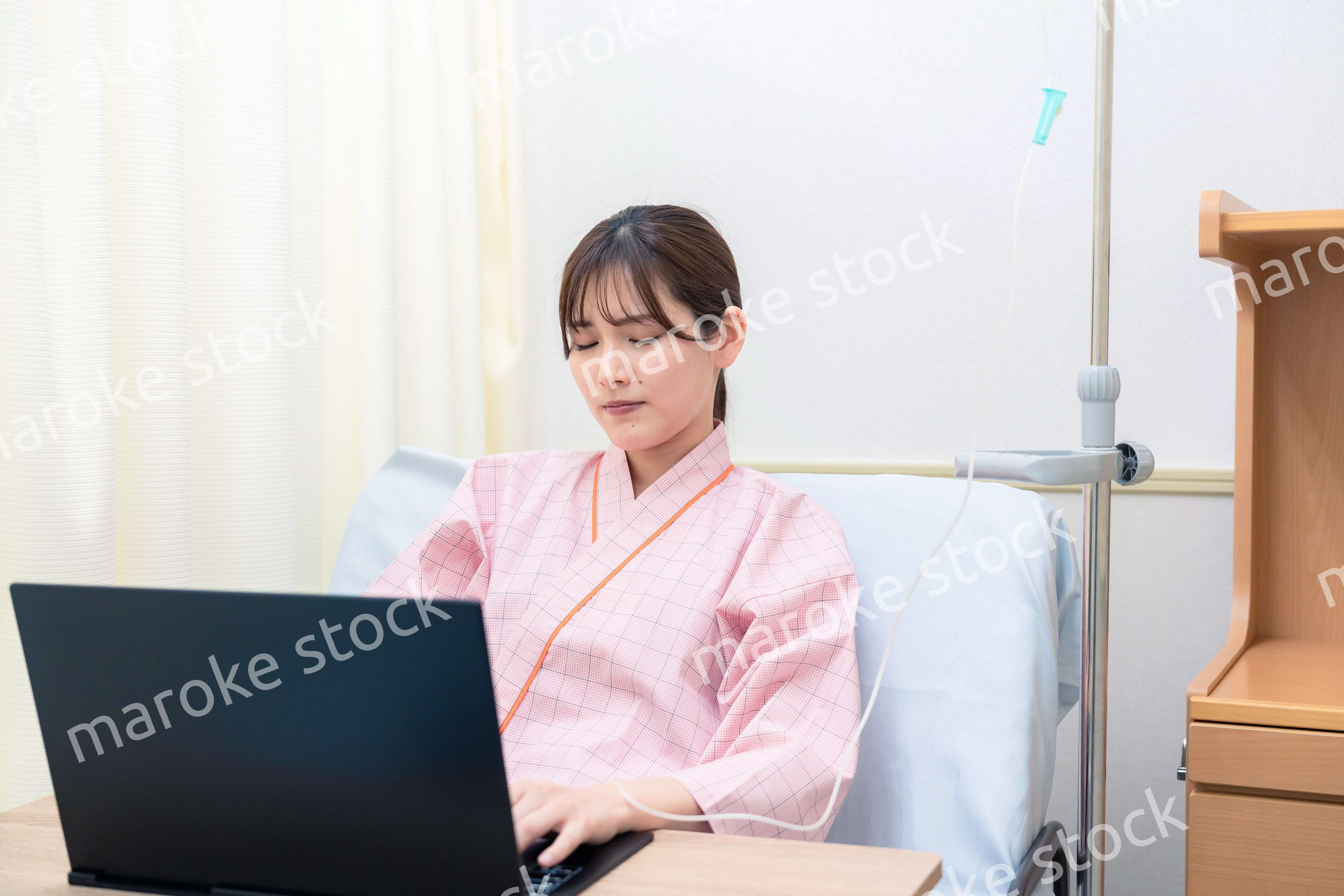 病室でパソコンを使う入院患者