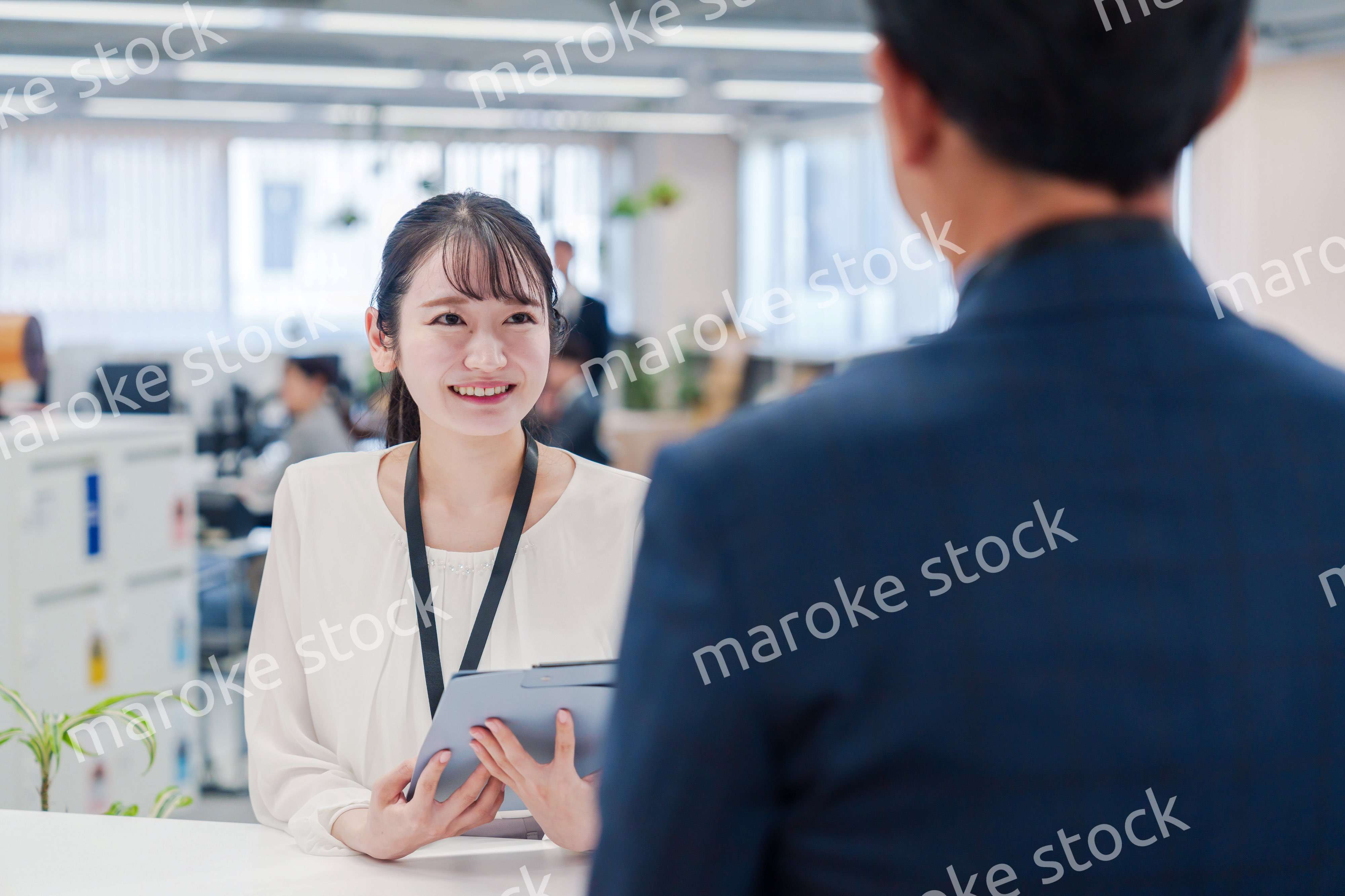 窓口で来客の対応をする女性スタッフ