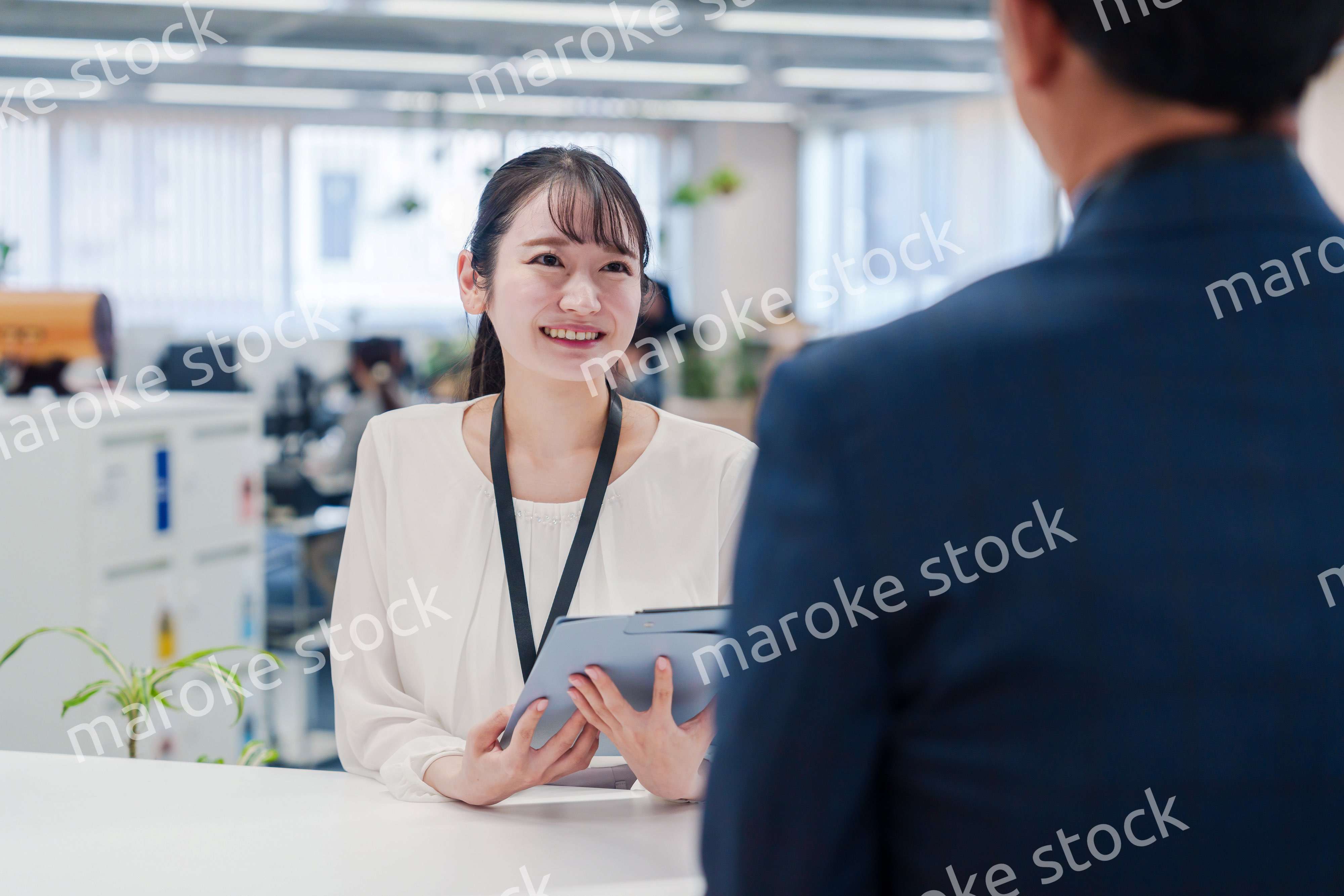 窓口で来客の対応をする女性スタッフ