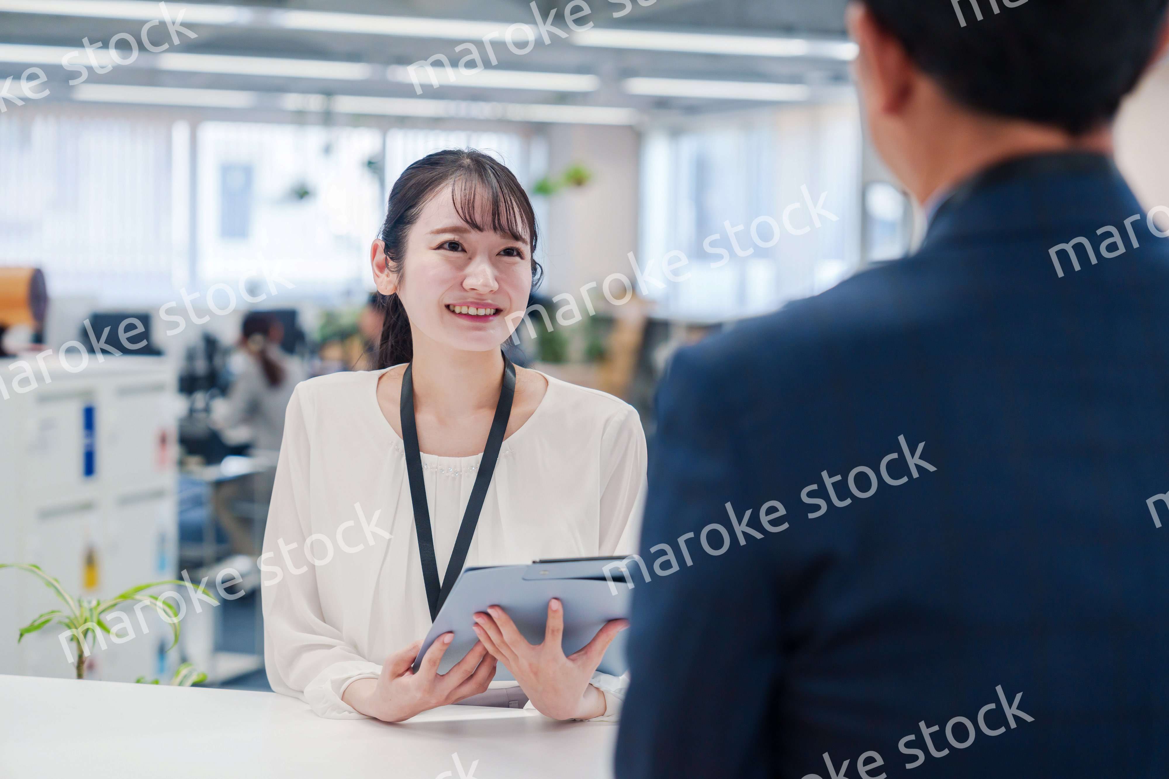 窓口で来客の対応をする女性スタッフ