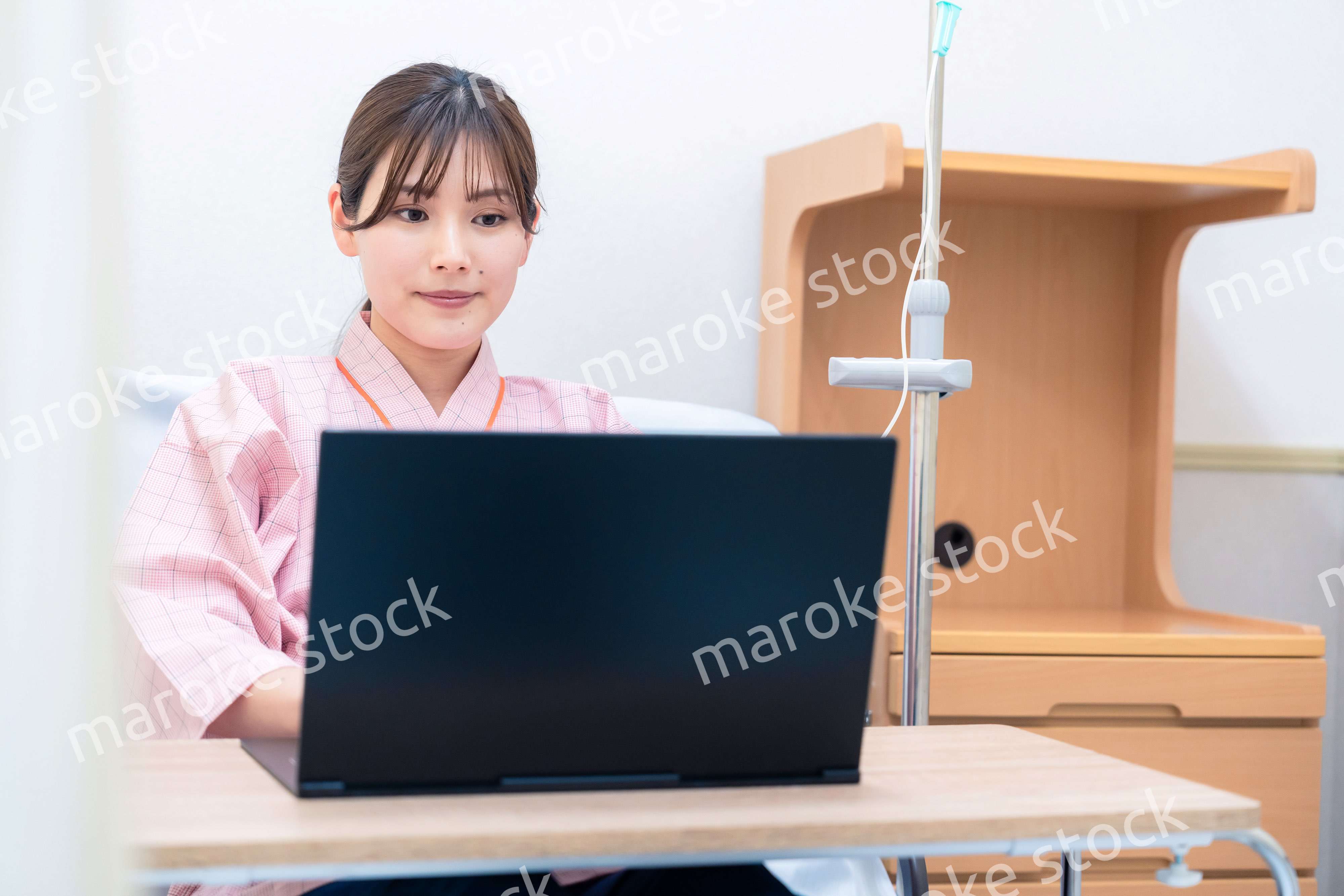 病室でパソコンを使う入院患者