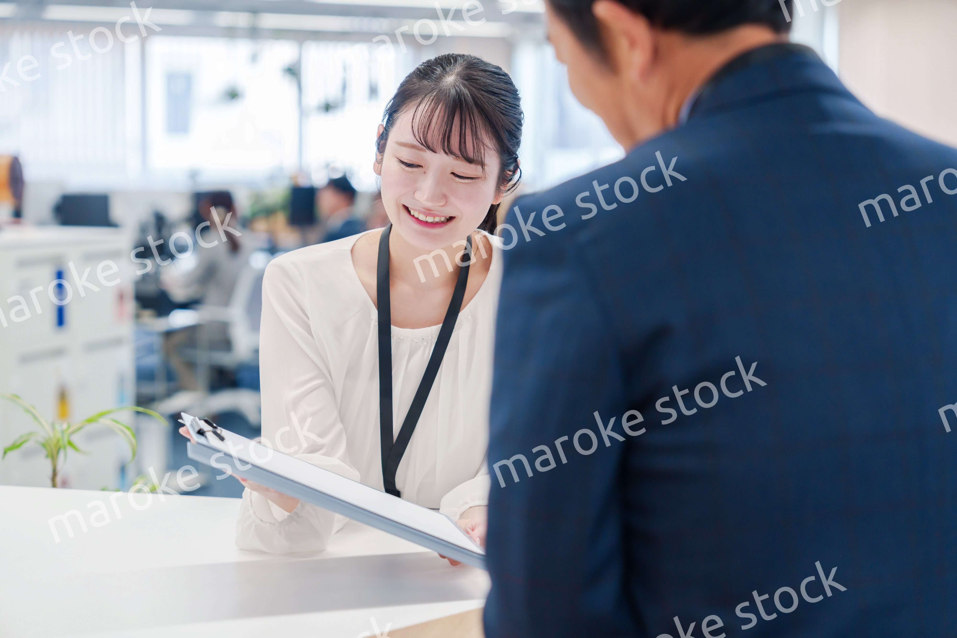 窓口で来客の対応をする女性スタッフ