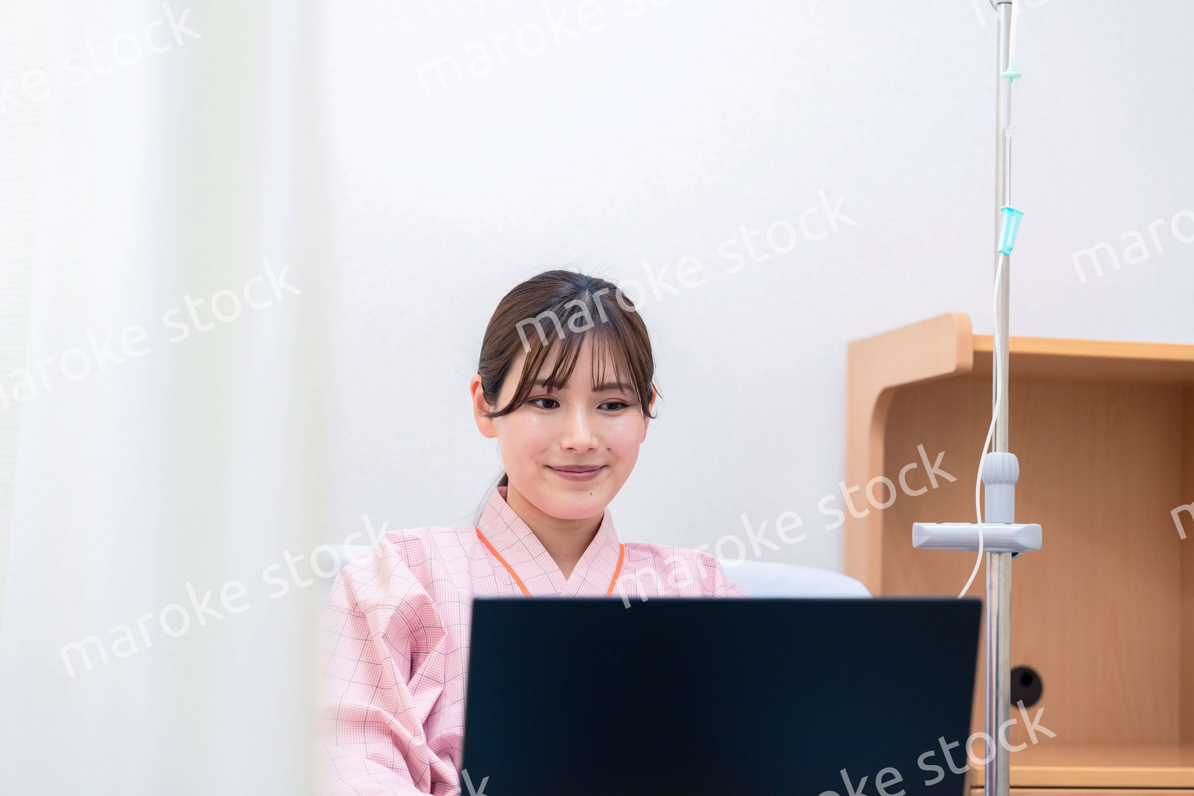 病室でパソコンを使う入院患者