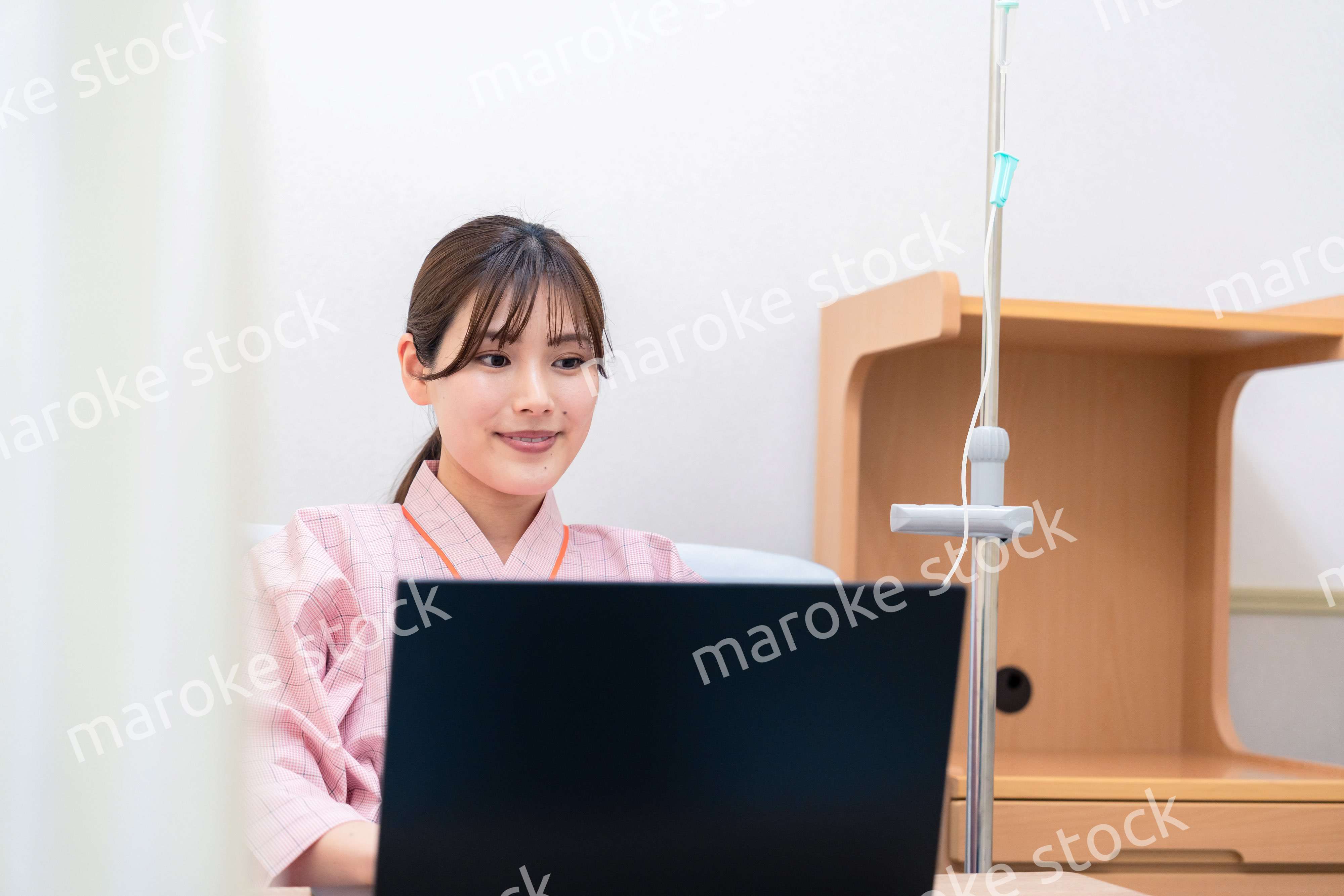 病室でパソコンを使う入院患者