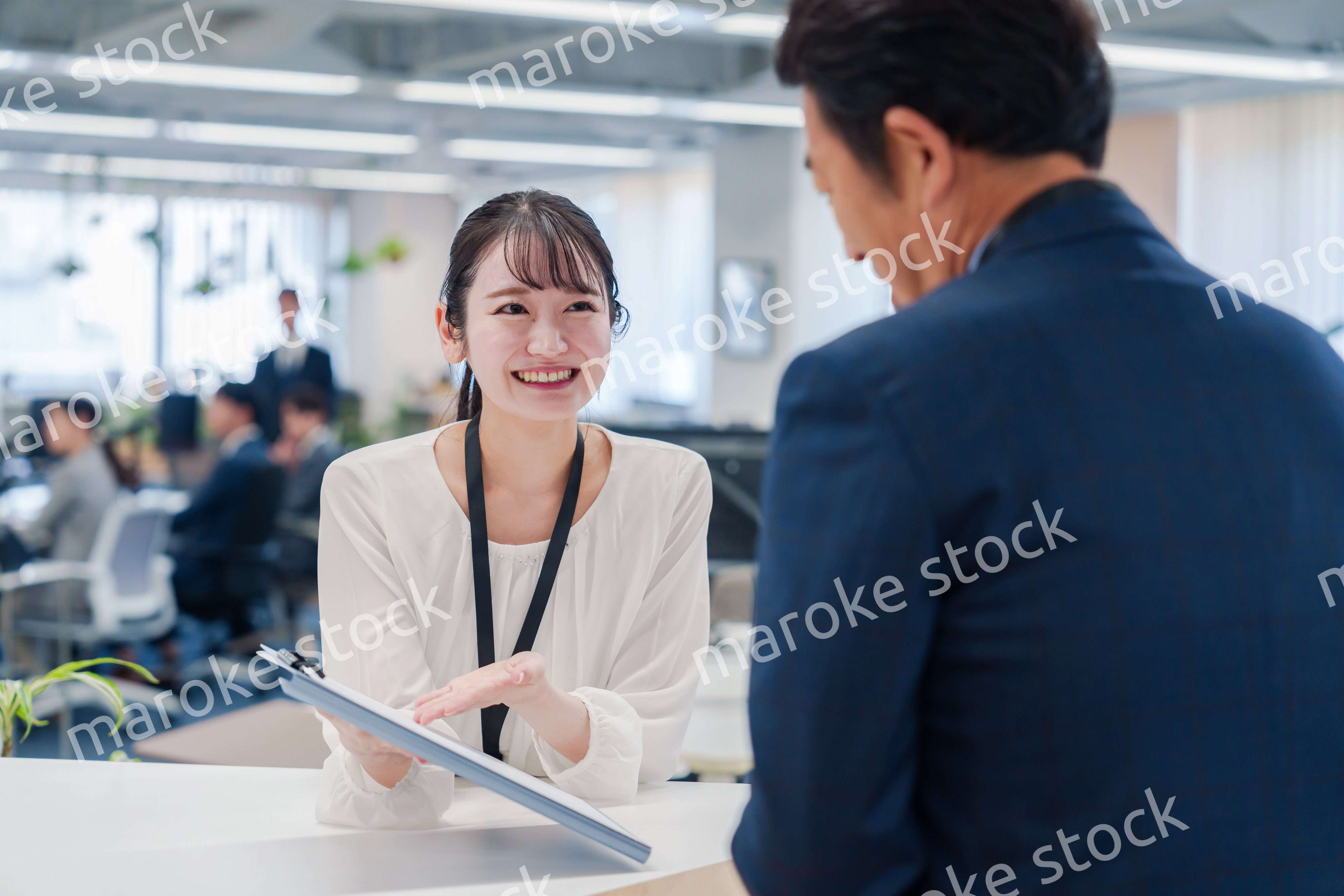 窓口で来客の対応をする女性スタッフ