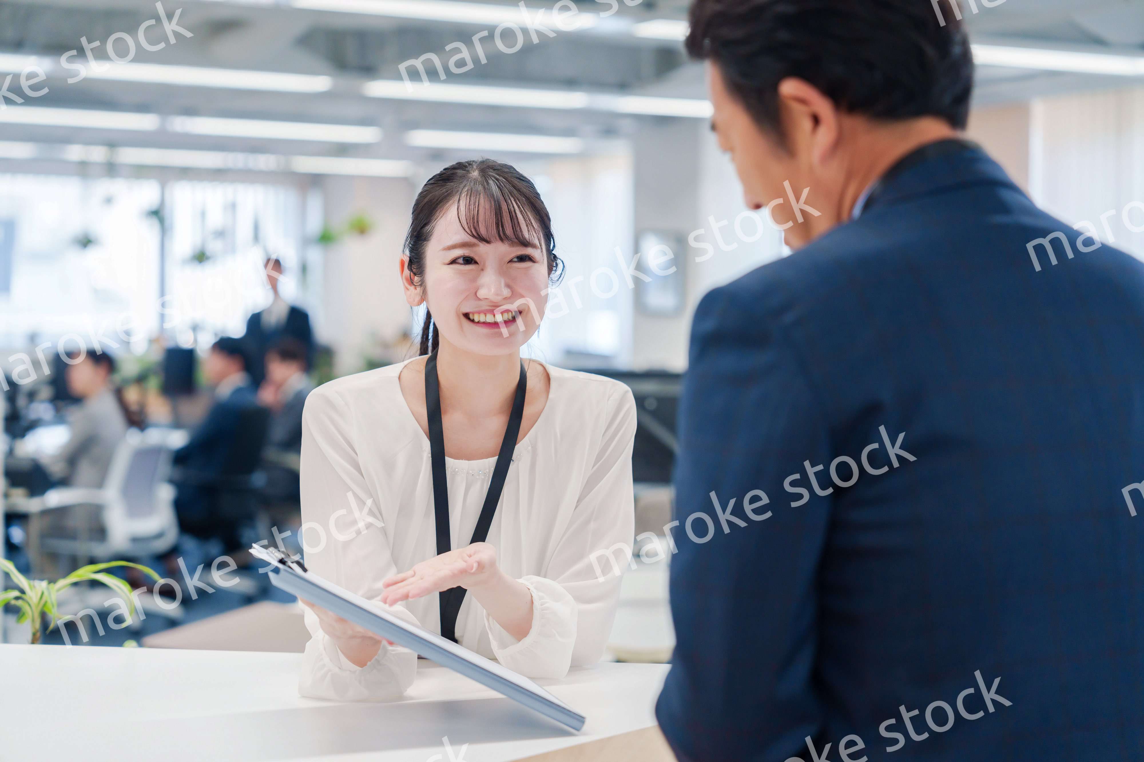 窓口で来客の対応をする女性スタッフ