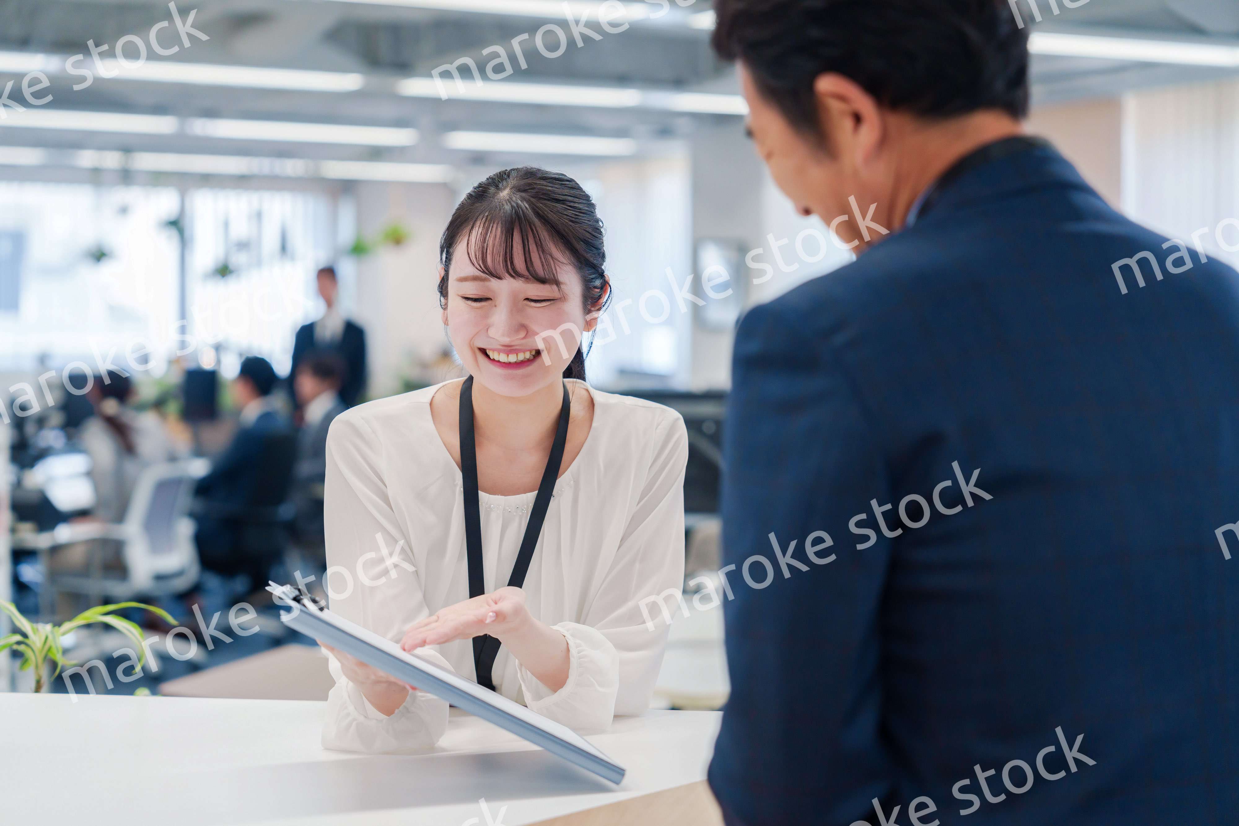 窓口で来客の対応をする女性スタッフ