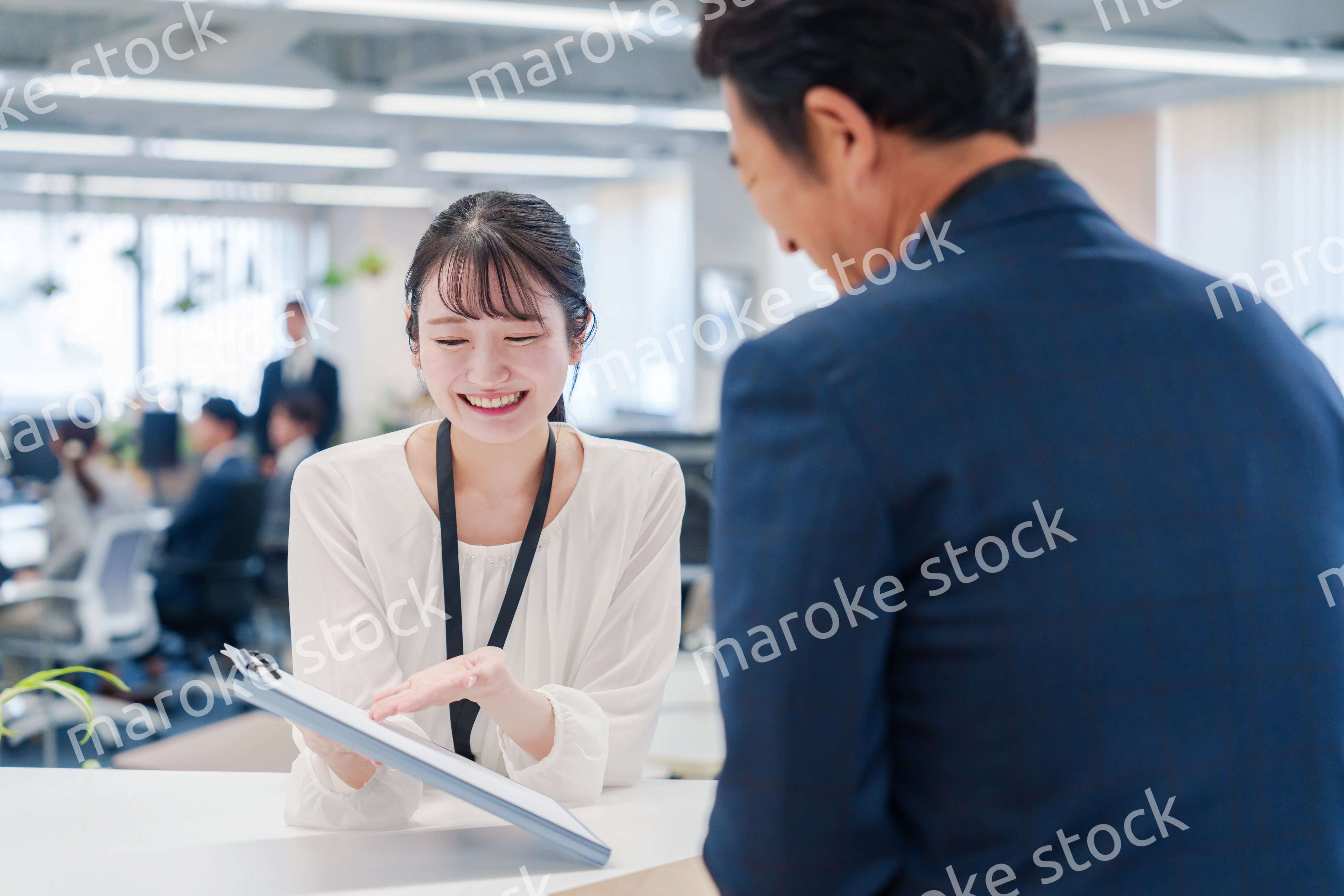 窓口で来客の対応をする女性スタッフ