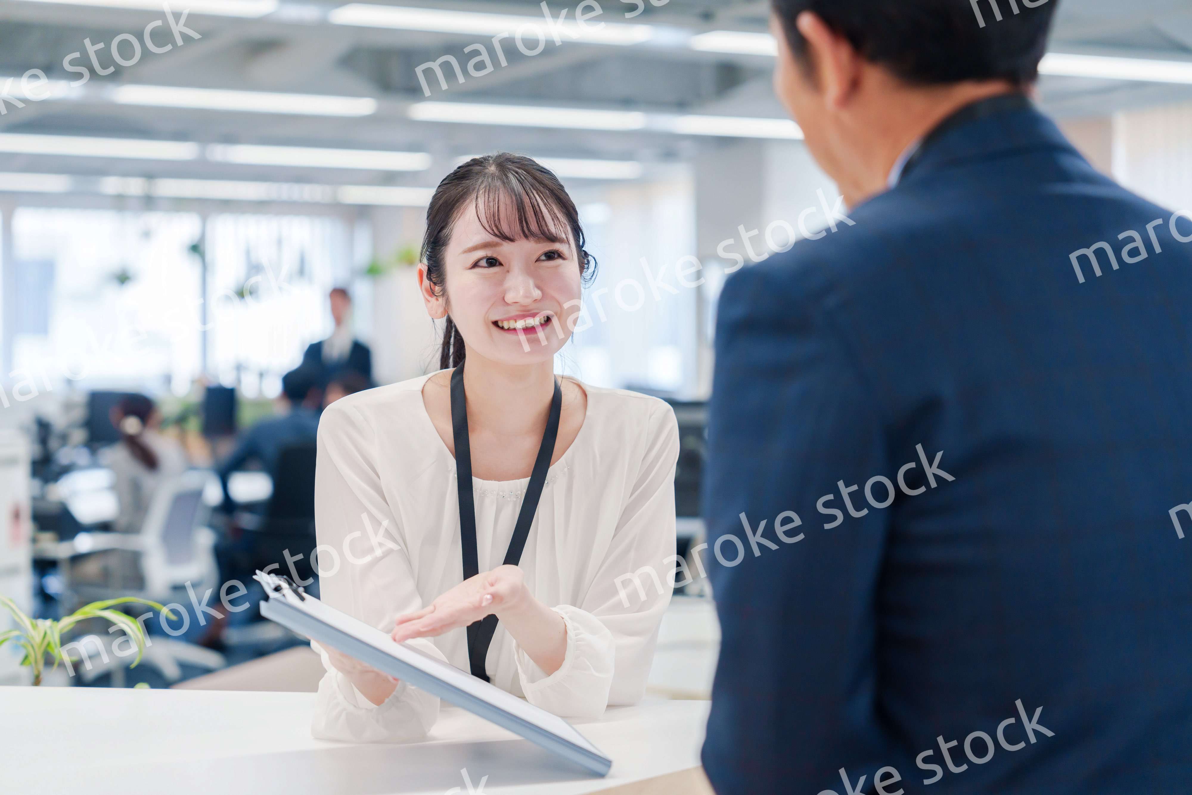 窓口で来客の対応をする女性スタッフ