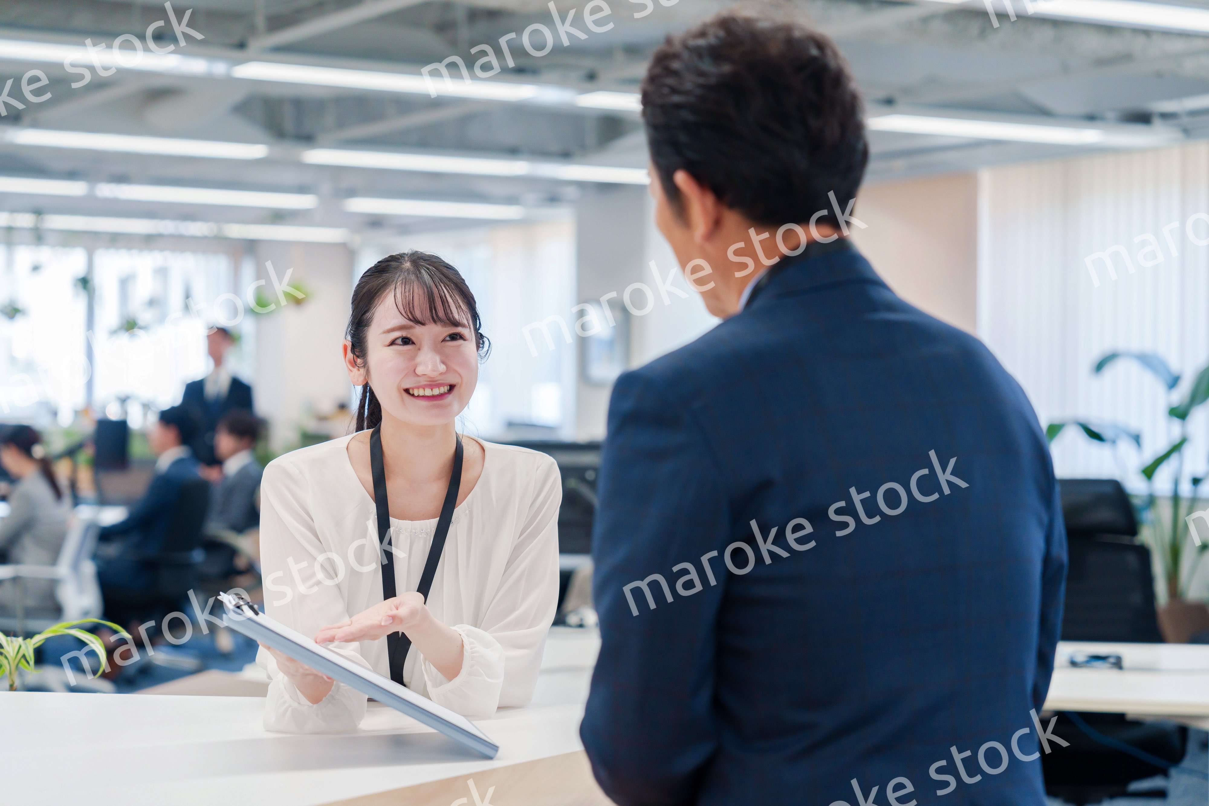 窓口で来客の対応をする女性スタッフ