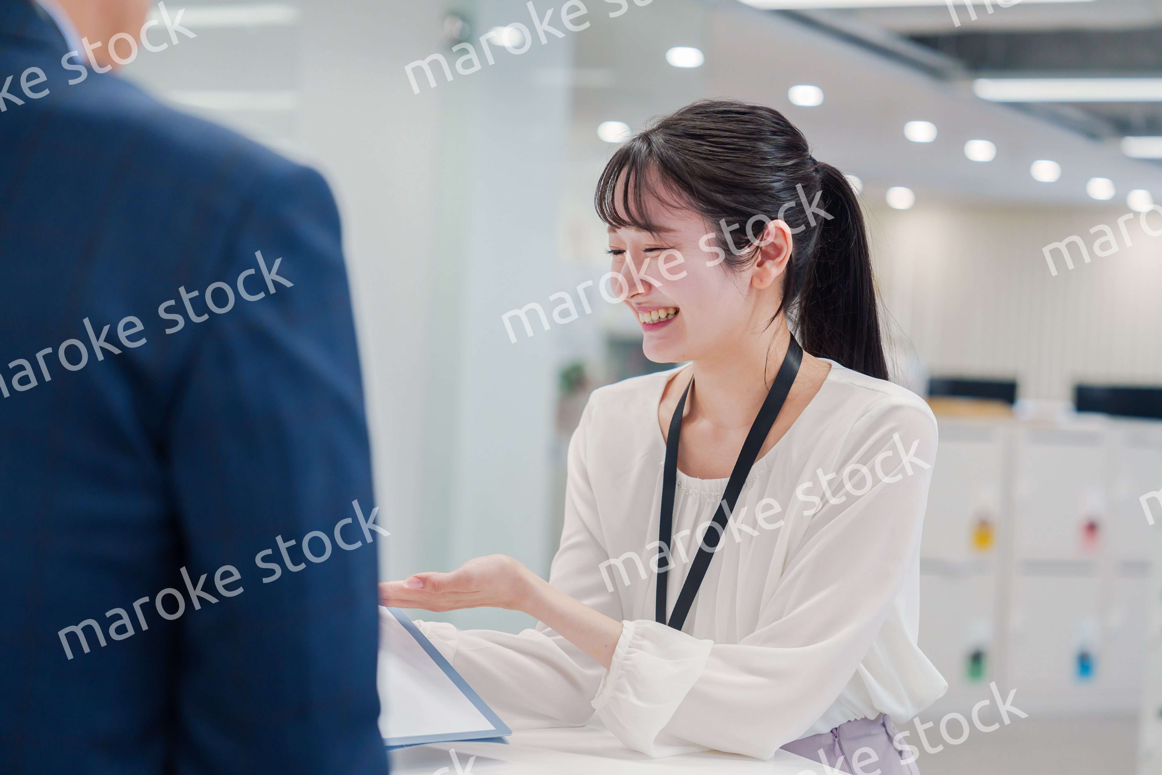 窓口で来客の対応をする女性スタッフ