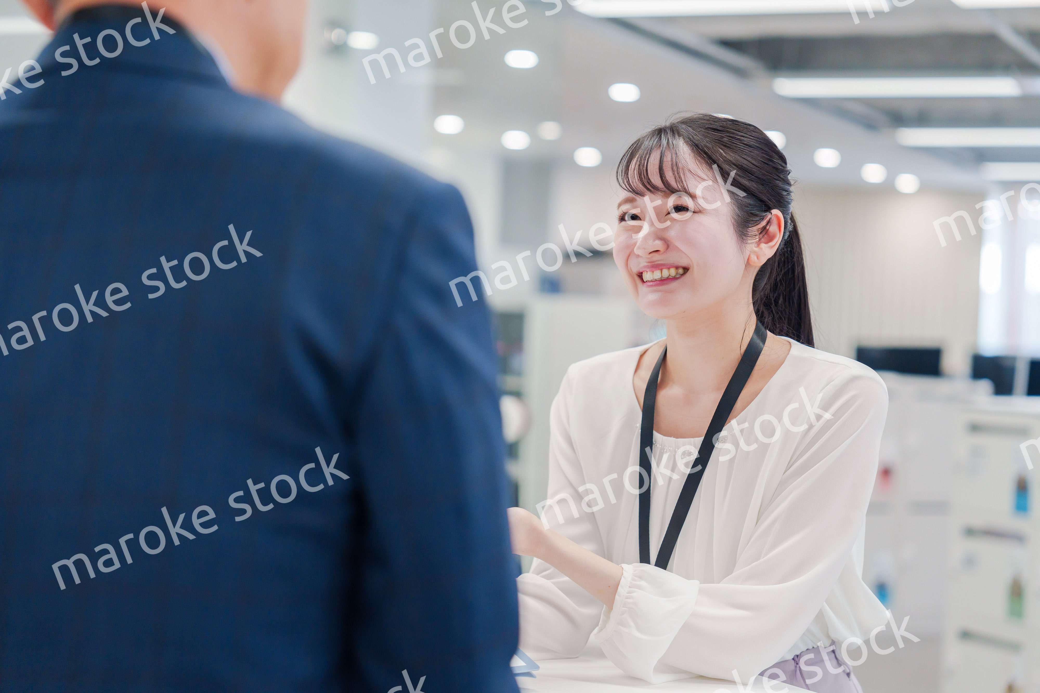 窓口で来客の対応をする女性スタッフ