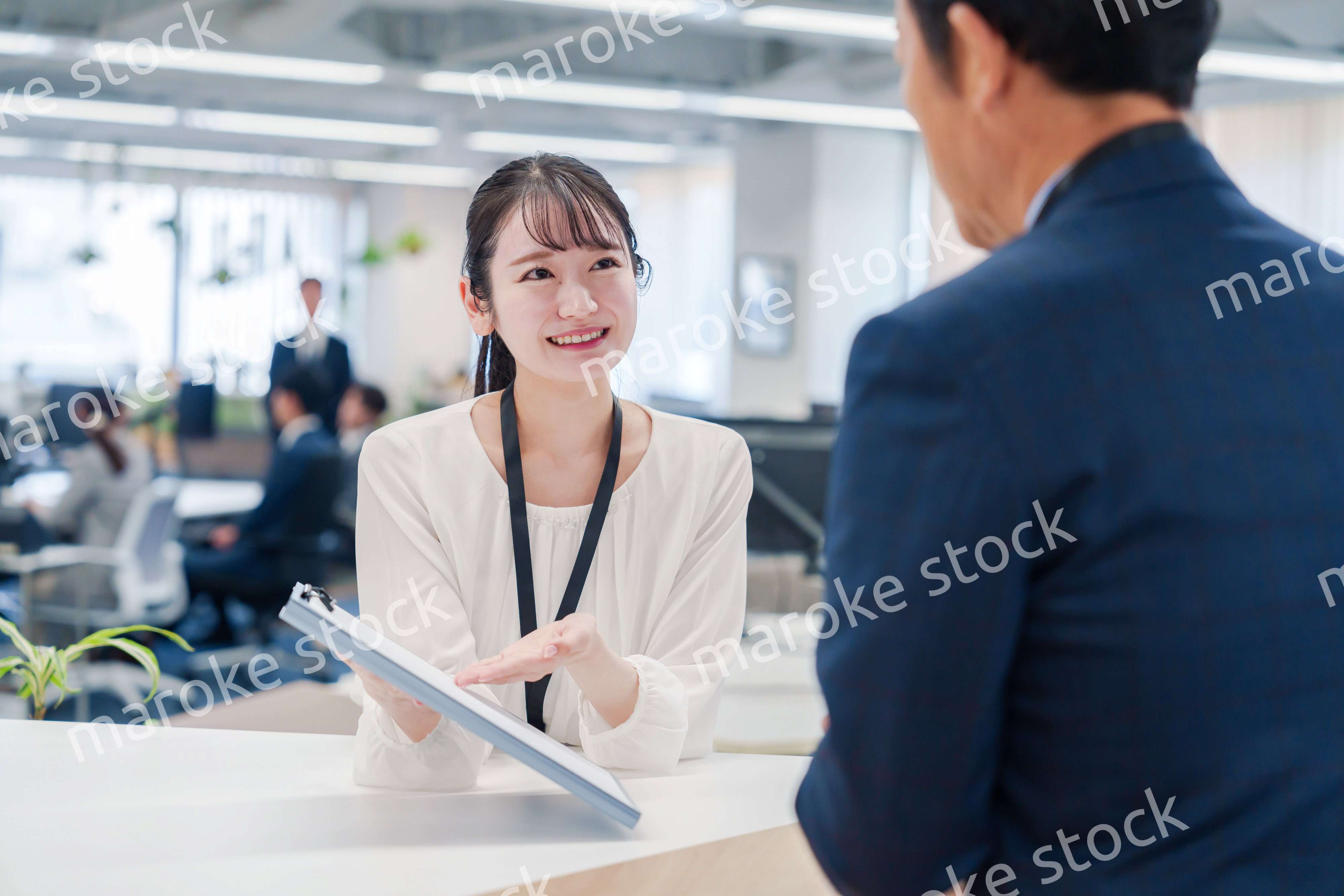 窓口で来客の対応をする女性スタッフ