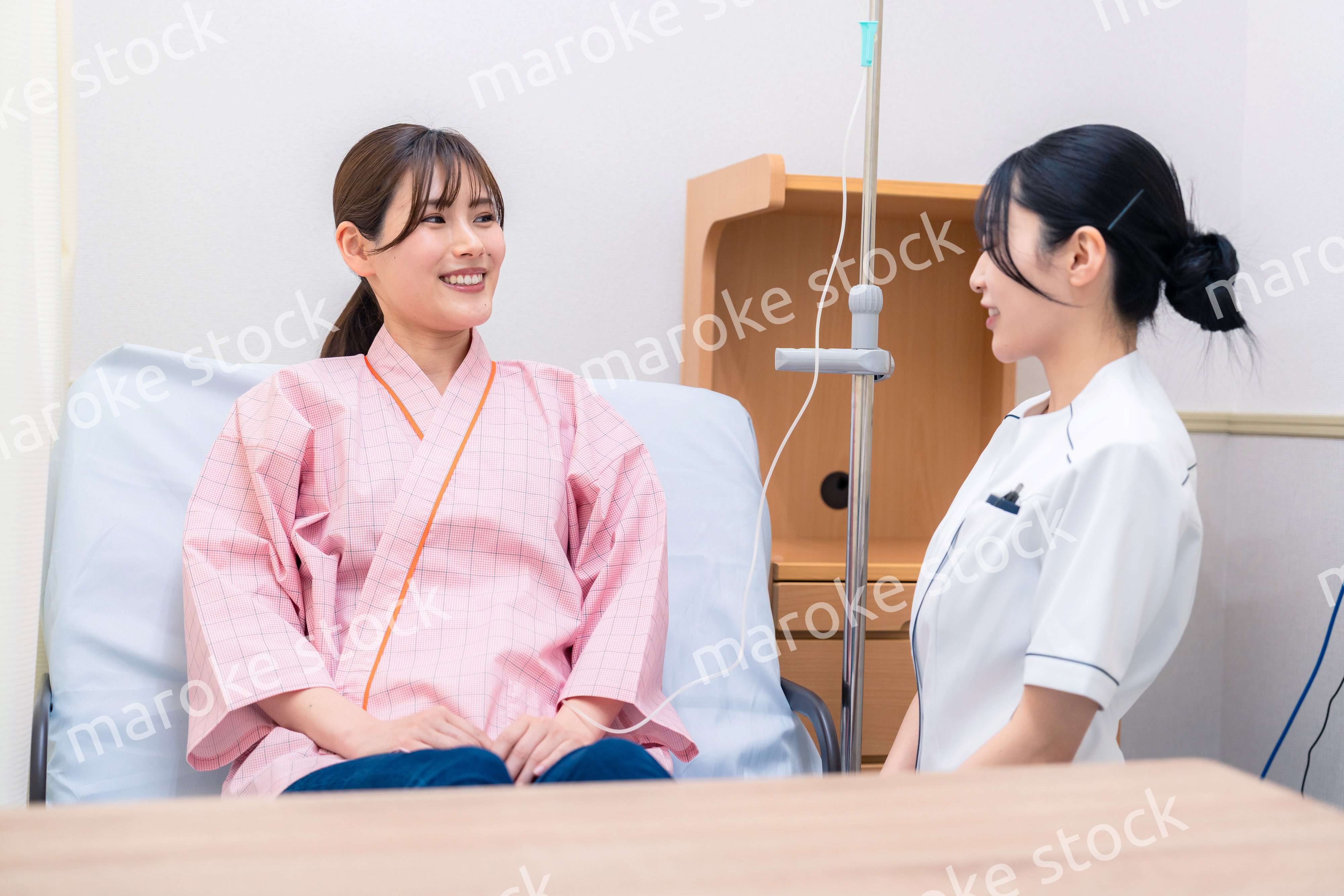 入院中の患者と話す医療従事者の女性