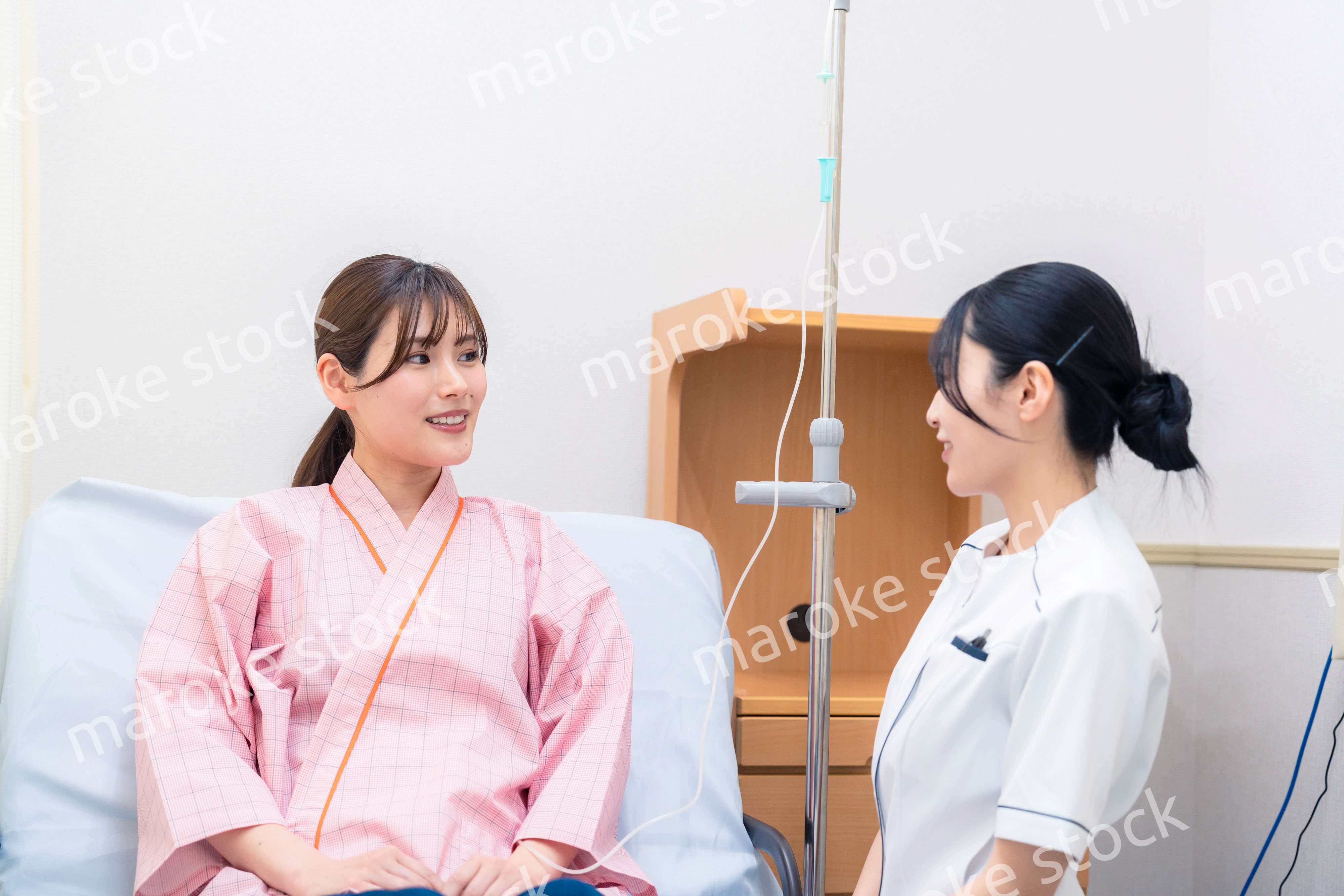入院中の患者と話す医療従事者の女性