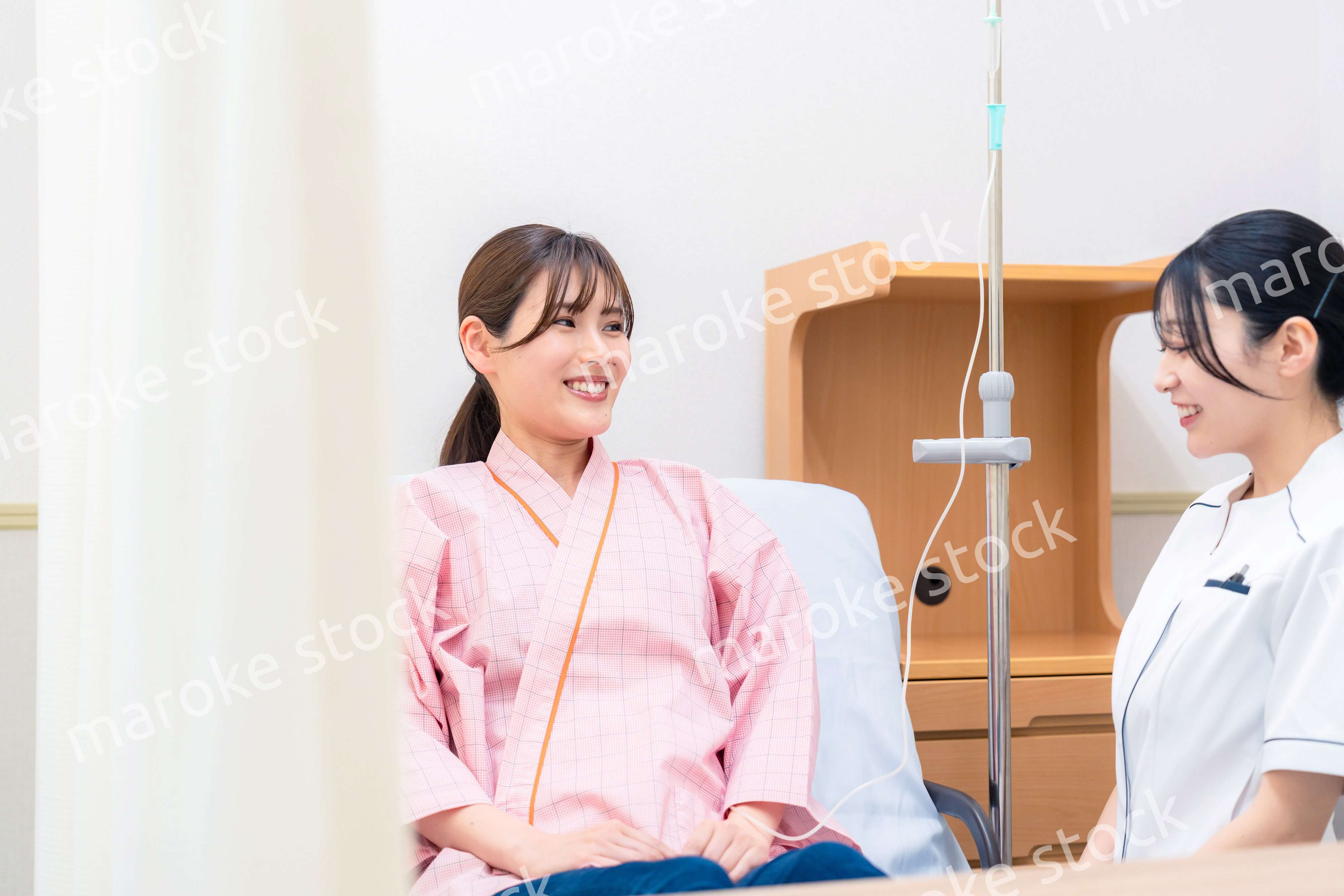 入院中の患者と話す医療従事者の女性