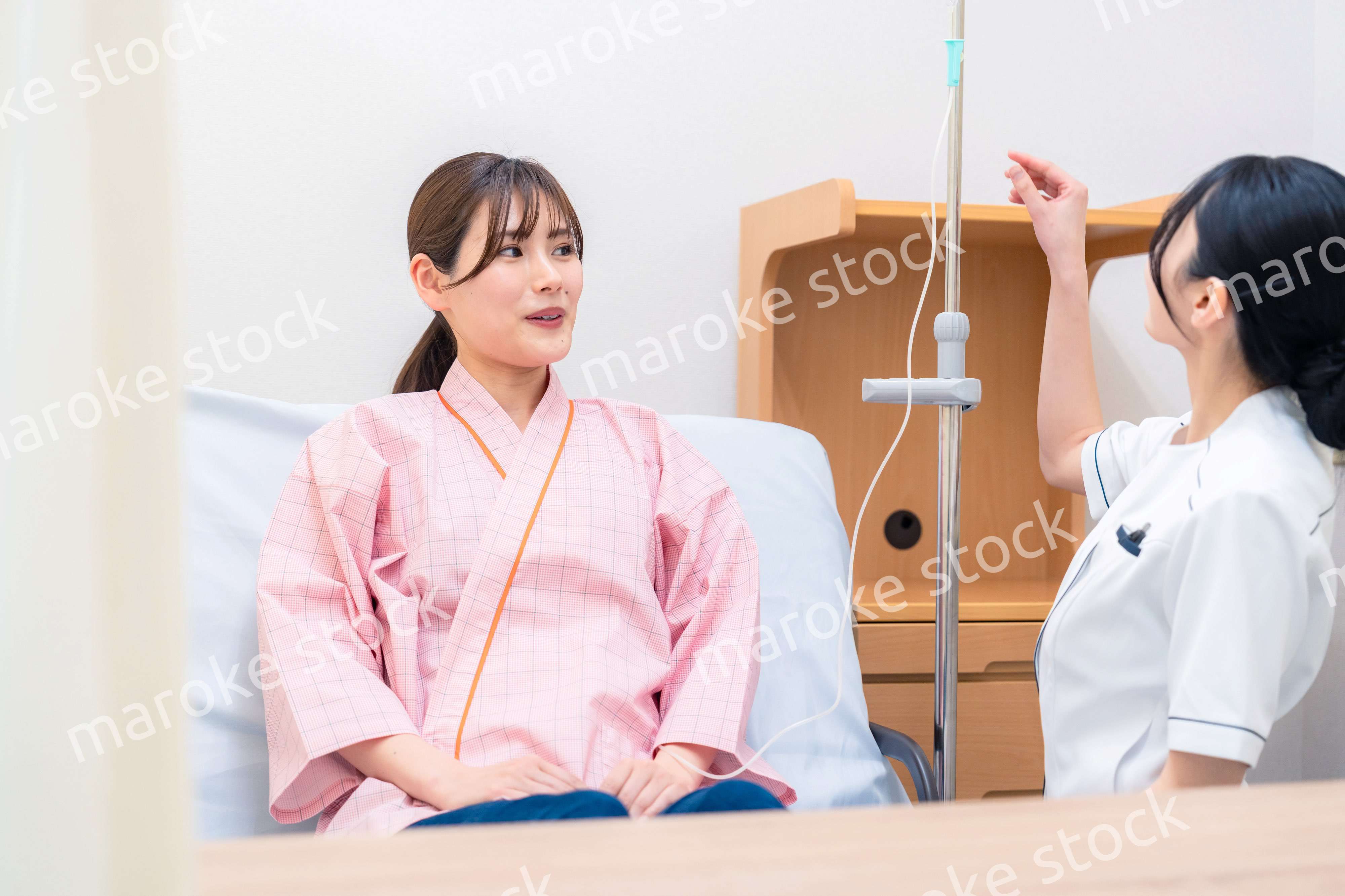 入院中の患者と話す医療従事者の女性