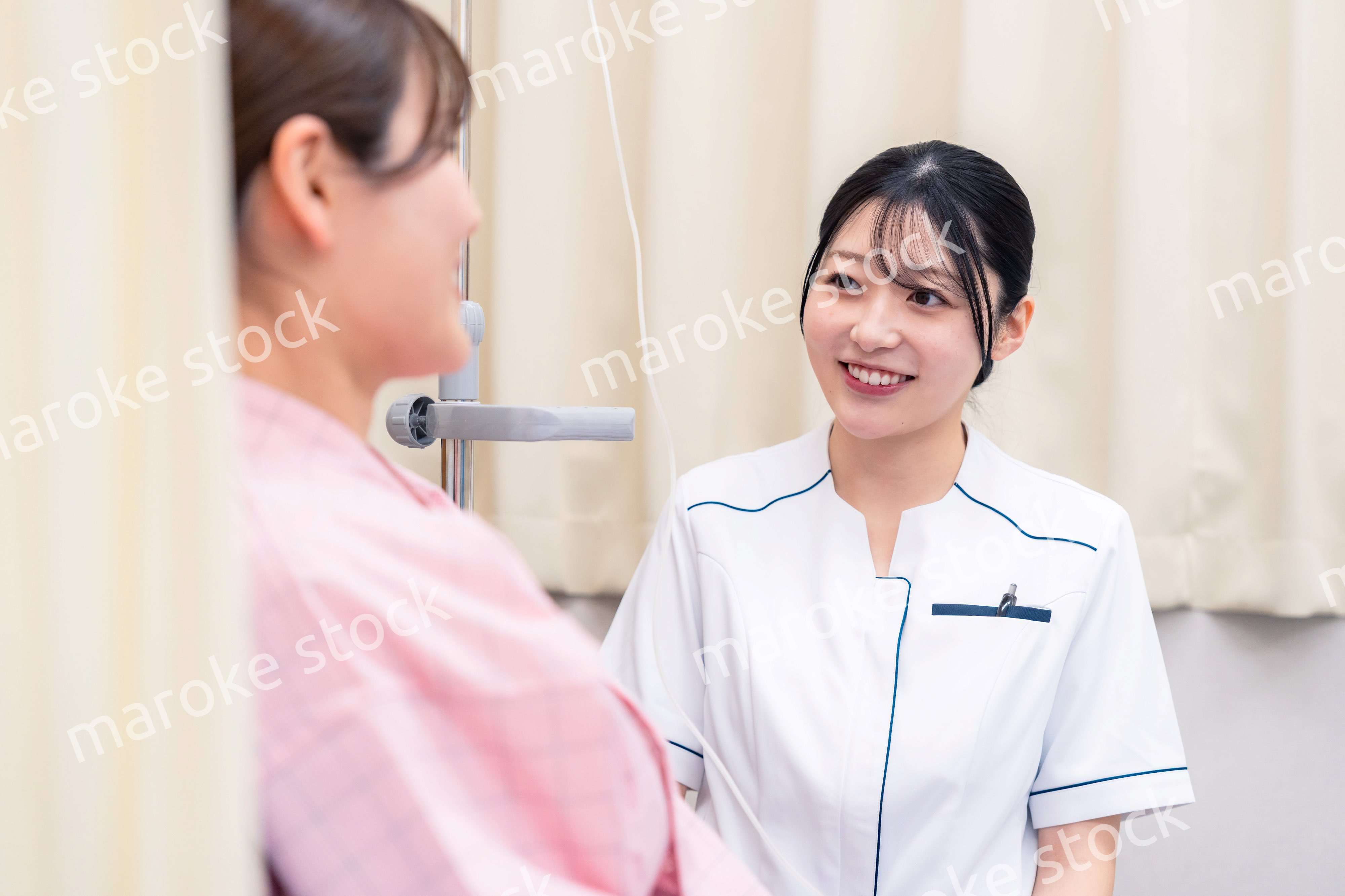 入院中の患者と話す医療従事者の女性