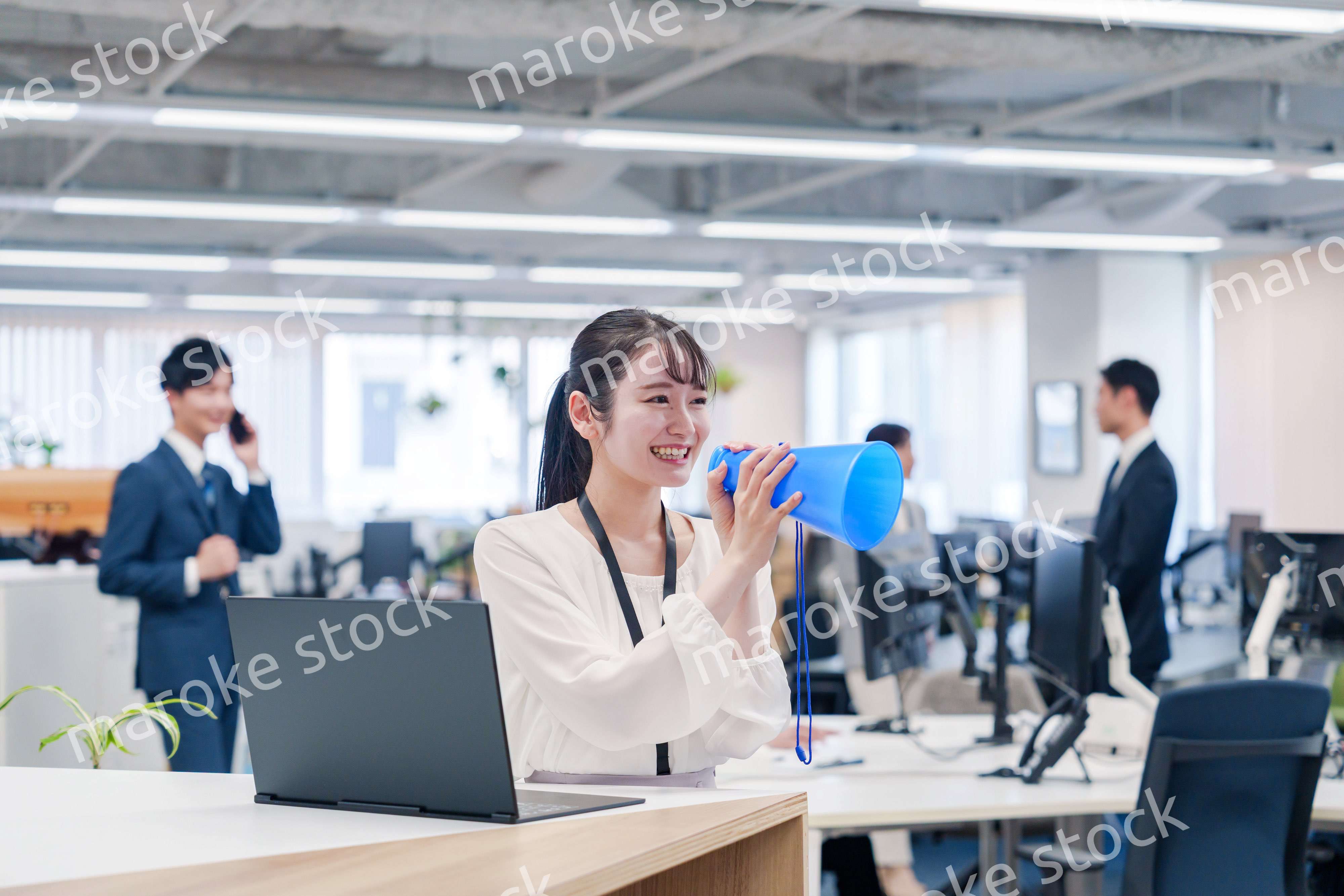 オフィスでメガホンを使って話す若い女性