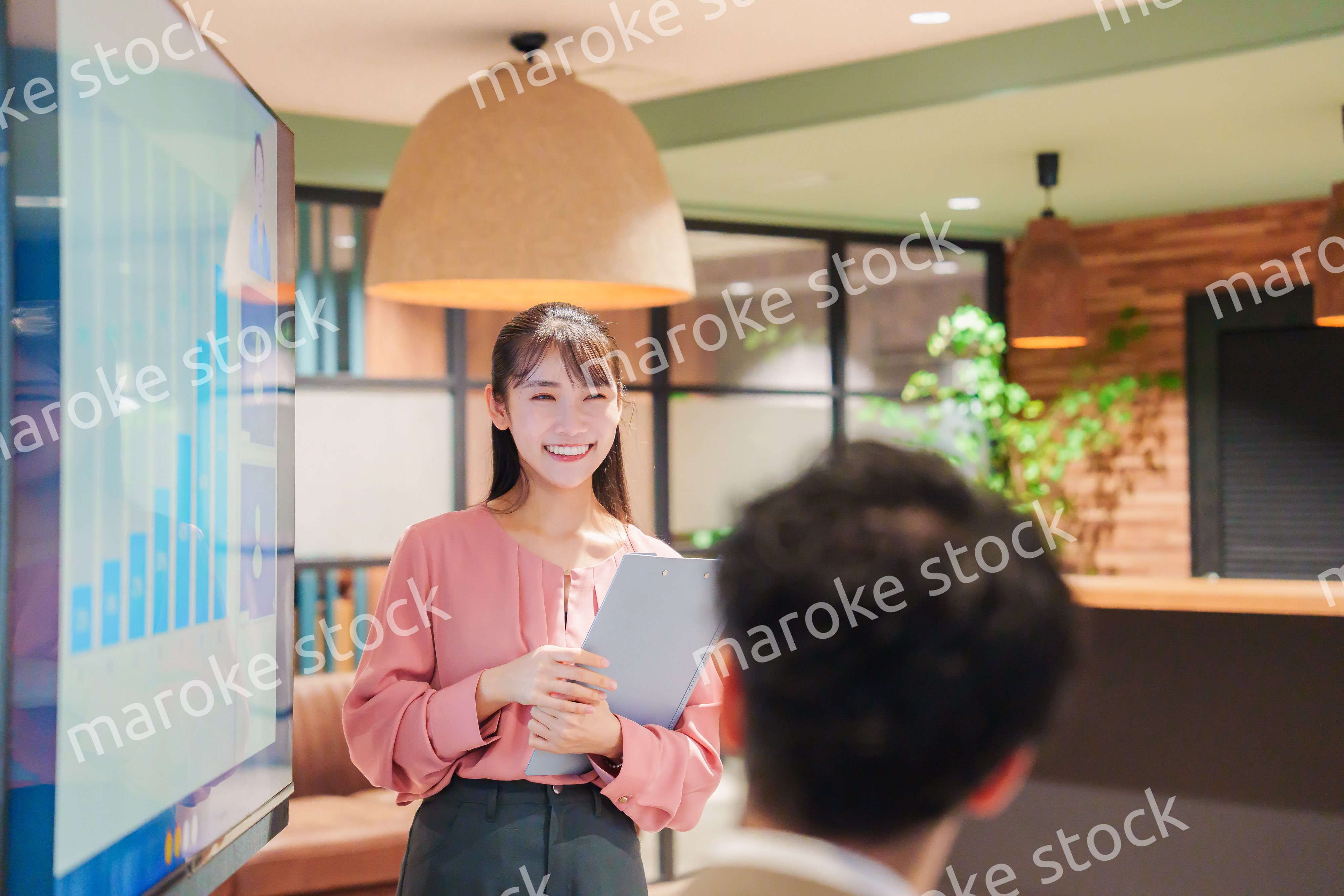 モダンオフィスでプレゼンをする若い女性