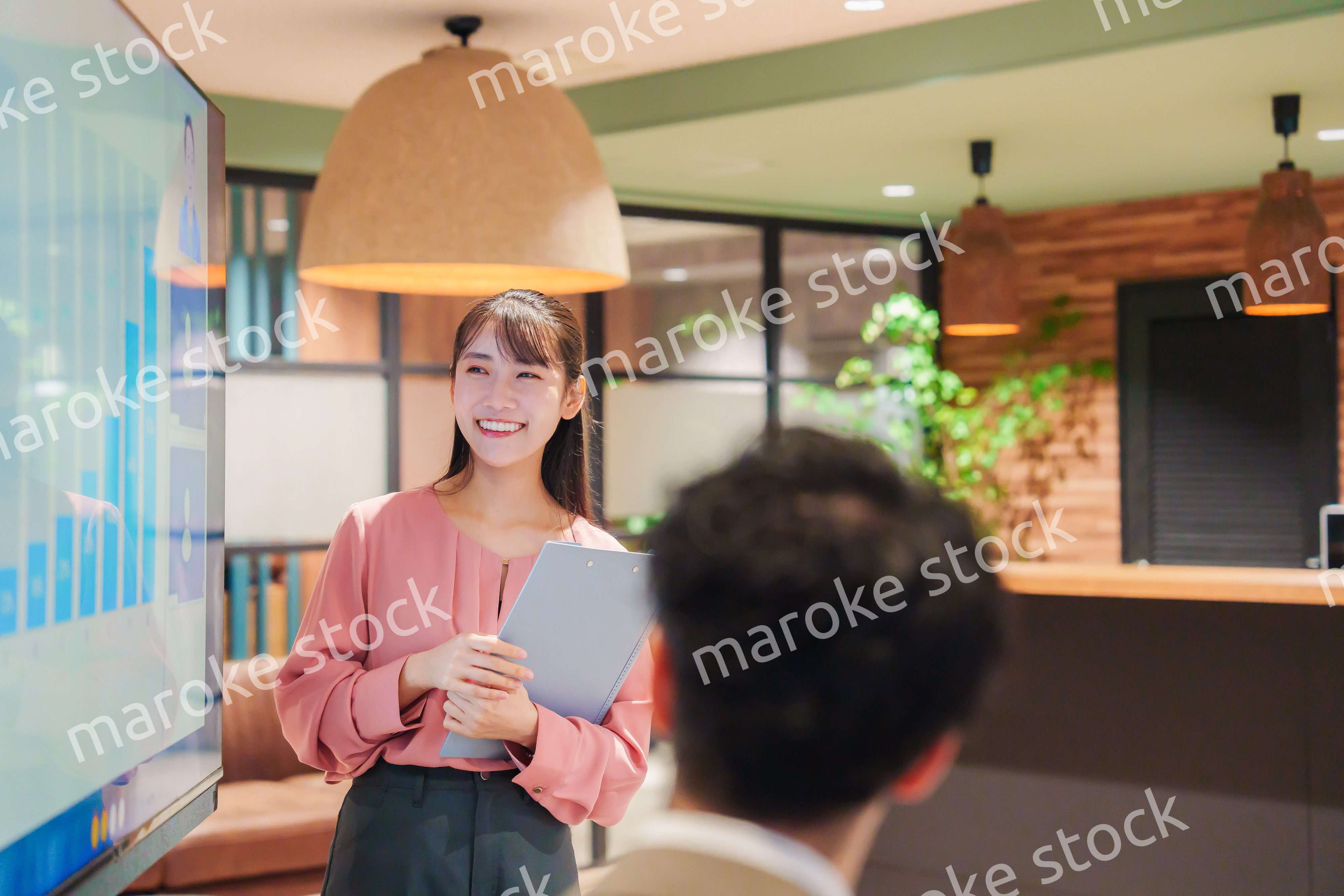 モダンオフィスでプレゼンをする若い女性