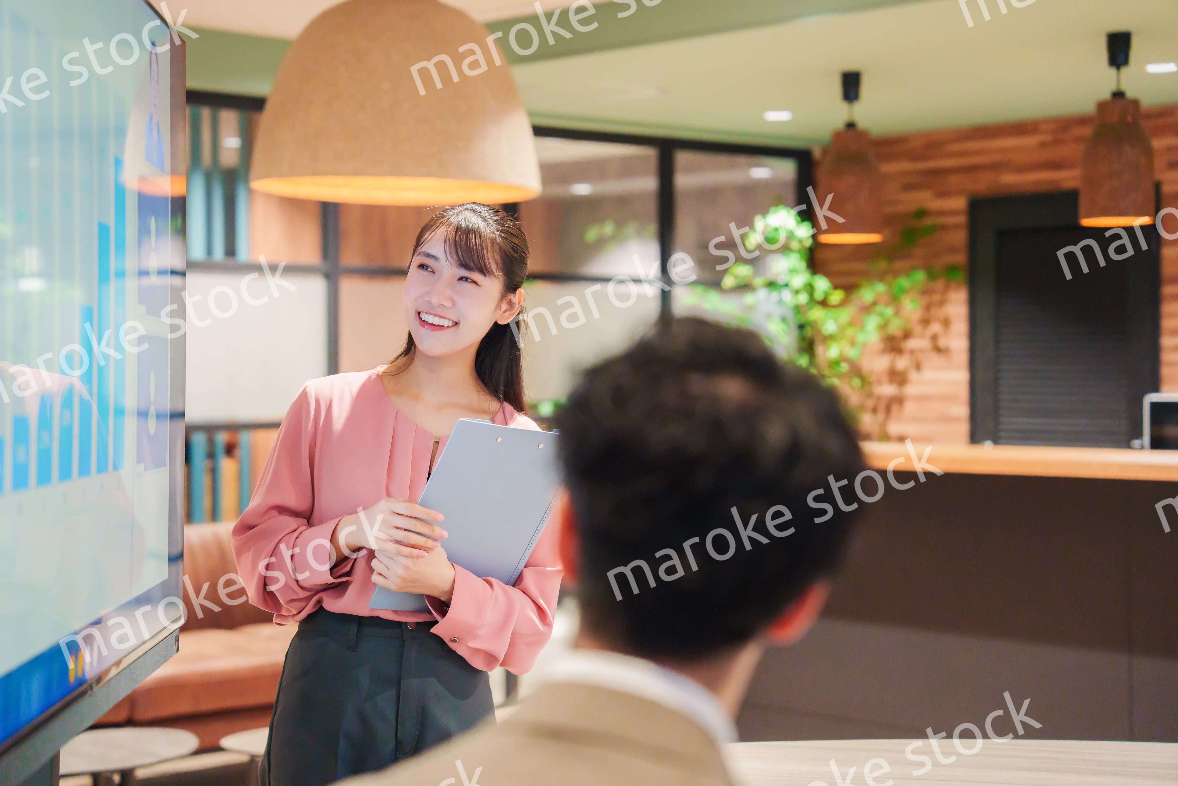 モダンオフィスでプレゼンをする若い女性