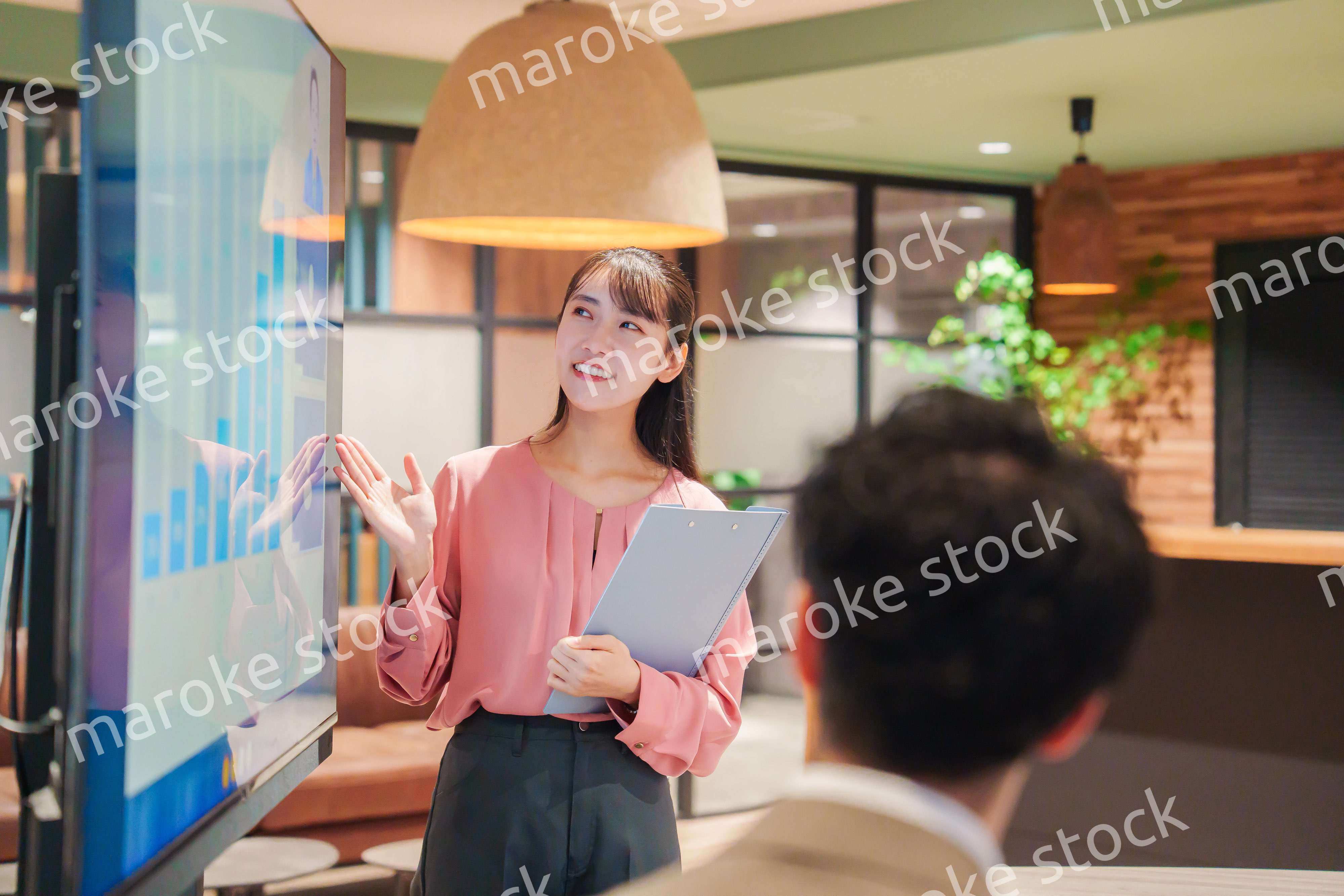 モダンオフィスでプレゼンをする若い女性