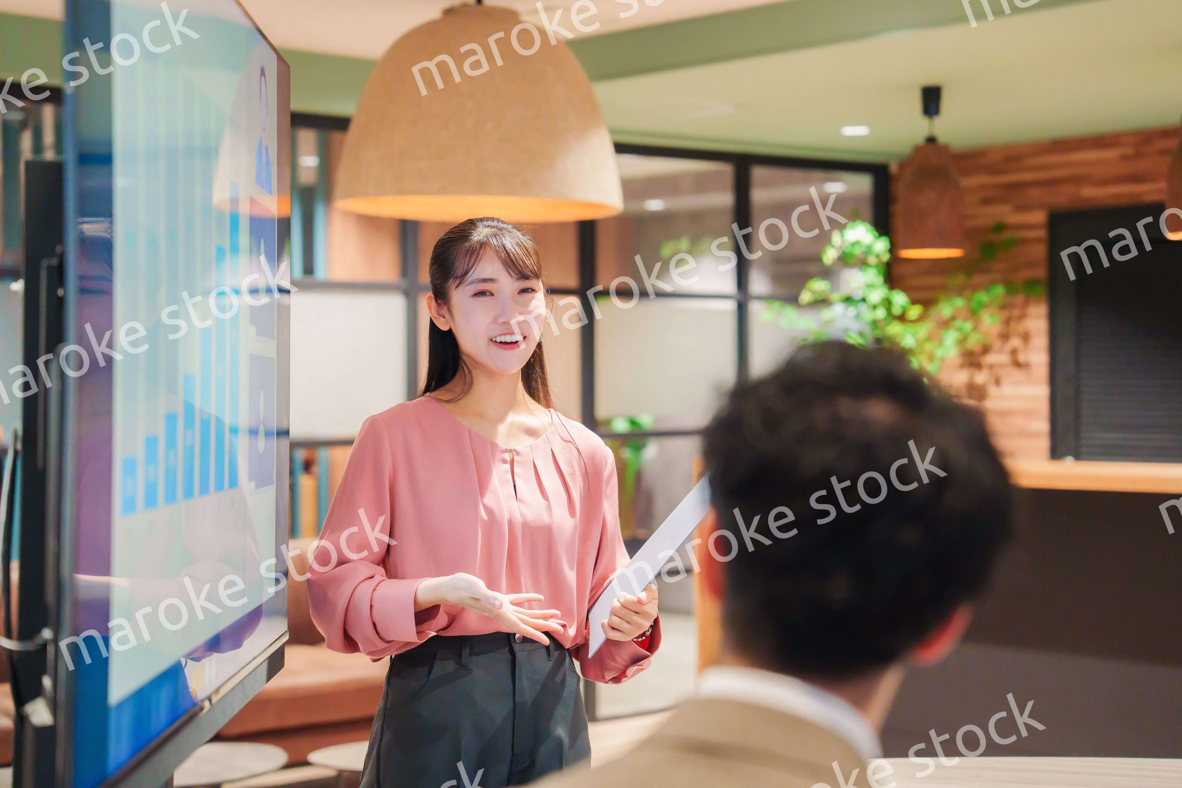 モダンオフィスでプレゼンをする若い女性