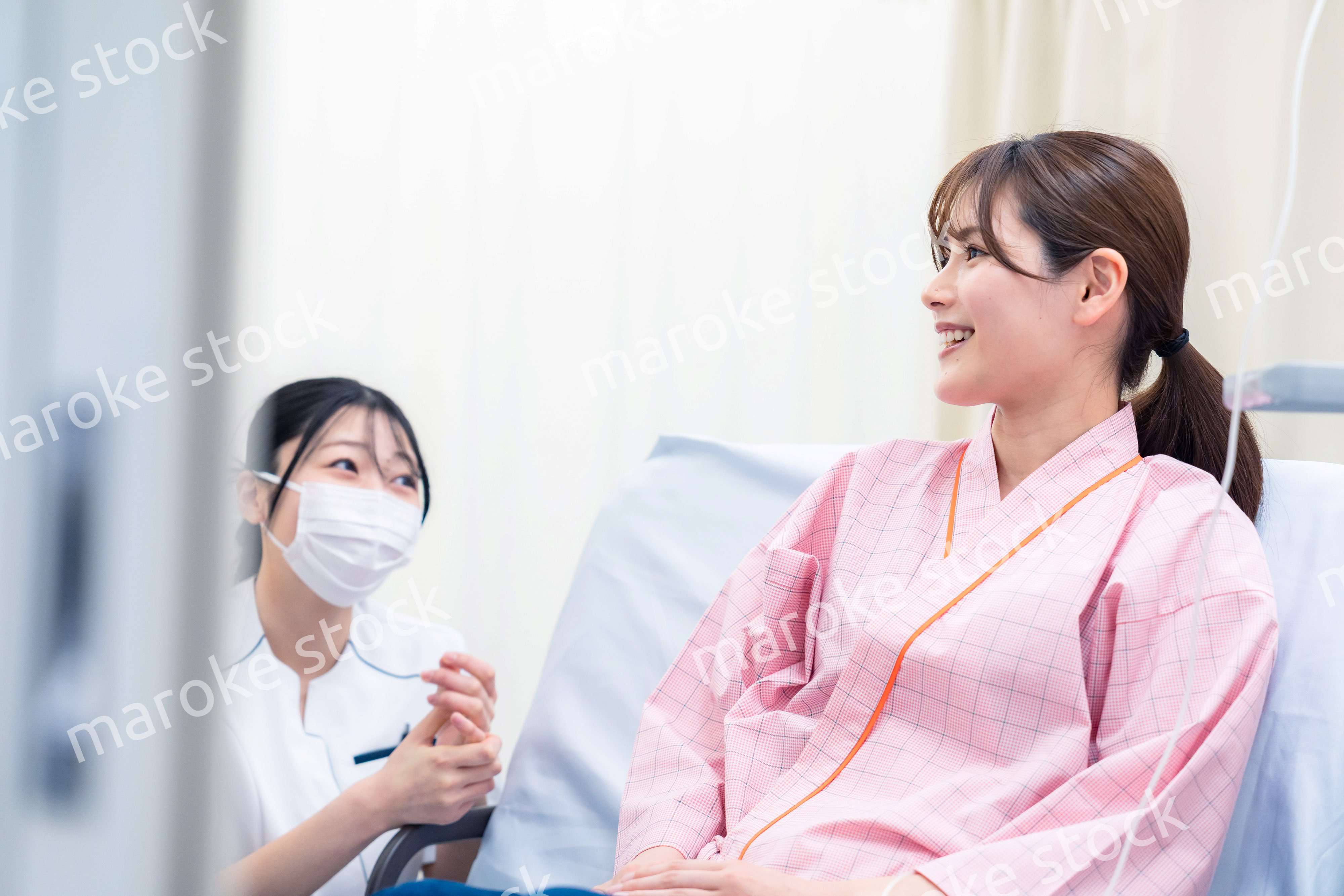 入院中の患者と話す医療従事者の女性