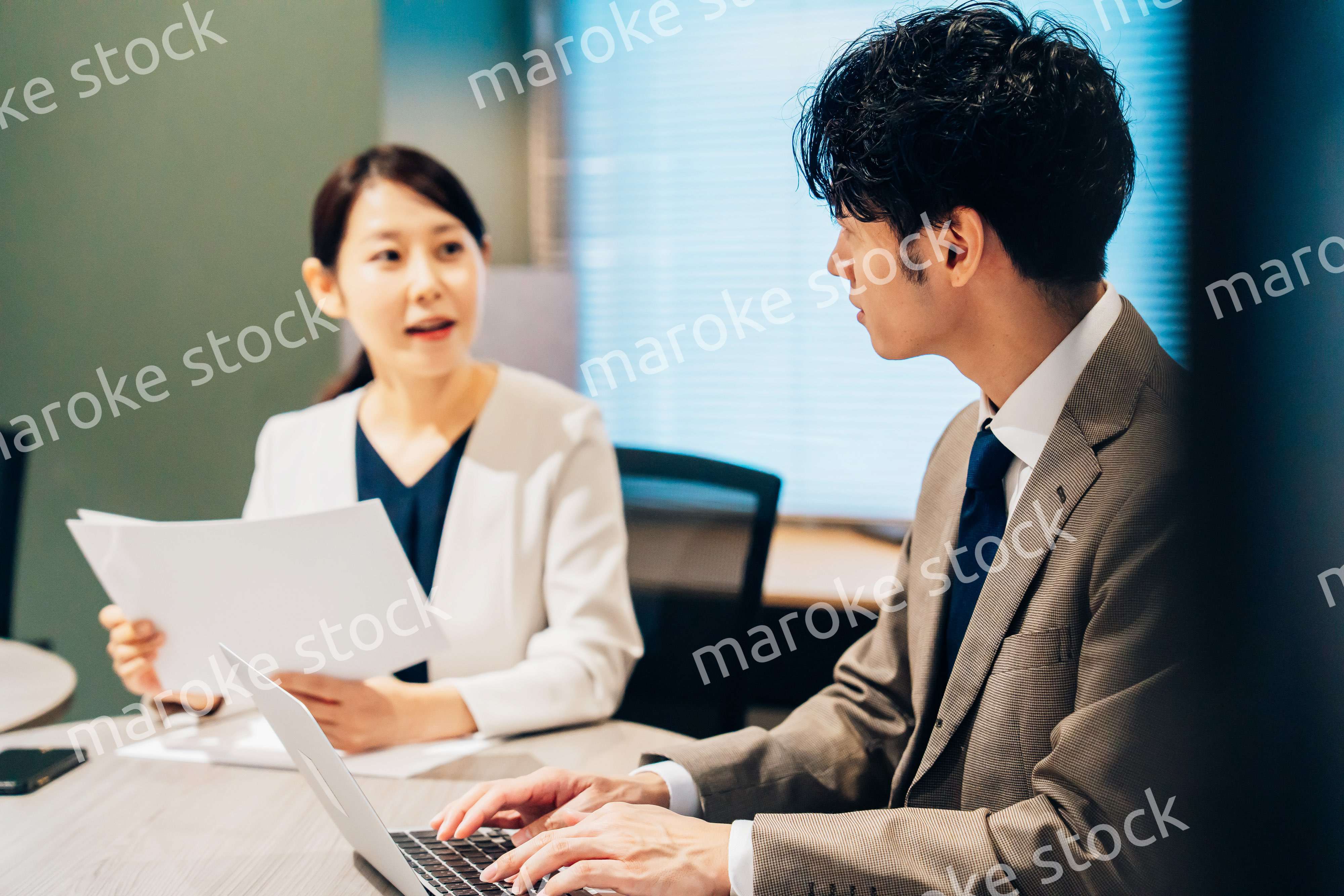 オフィスで打ち合わせをするミドルの女性