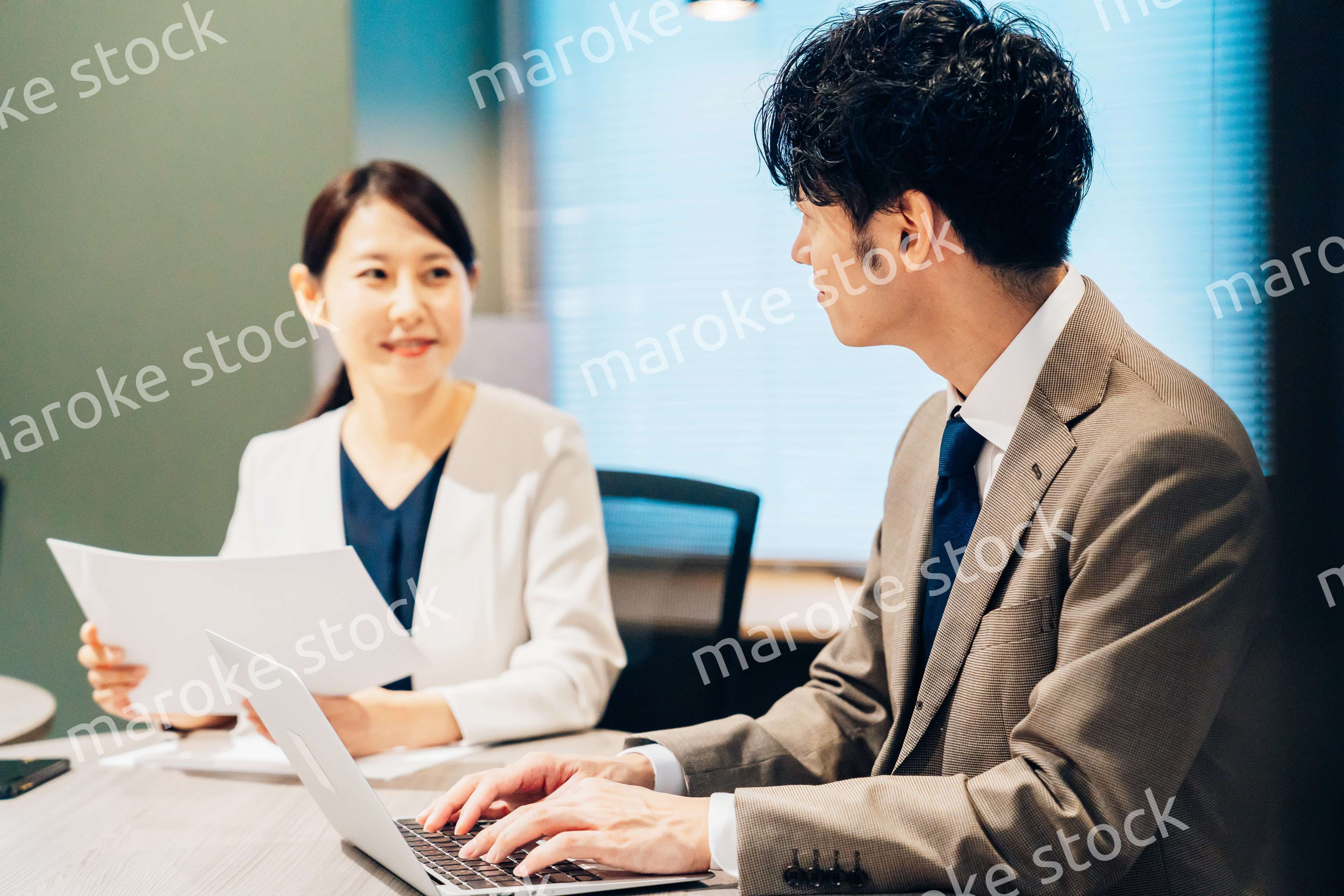 オフィスで打ち合わせをするミドルの女性