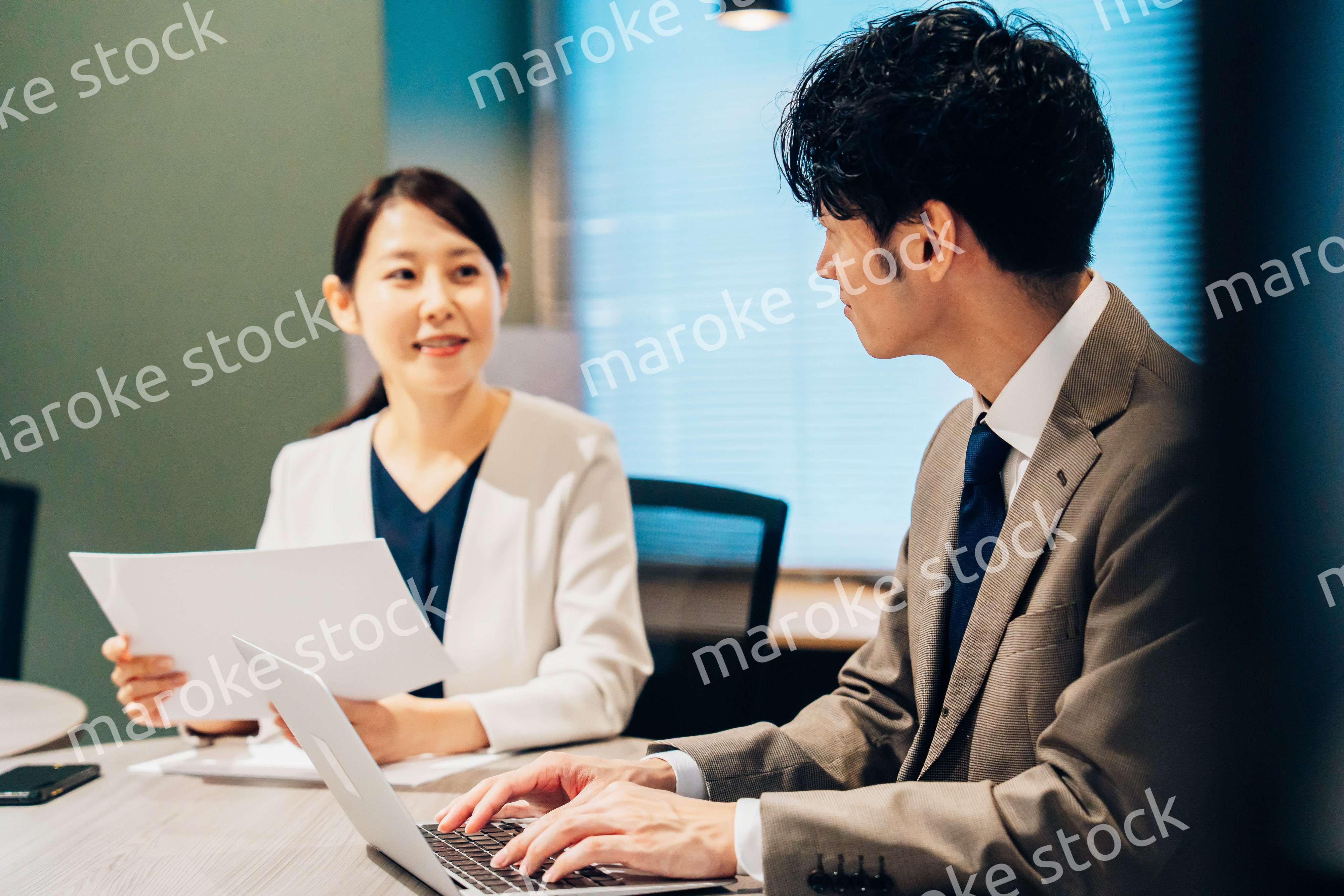 オフィスで打ち合わせをするミドルの女性