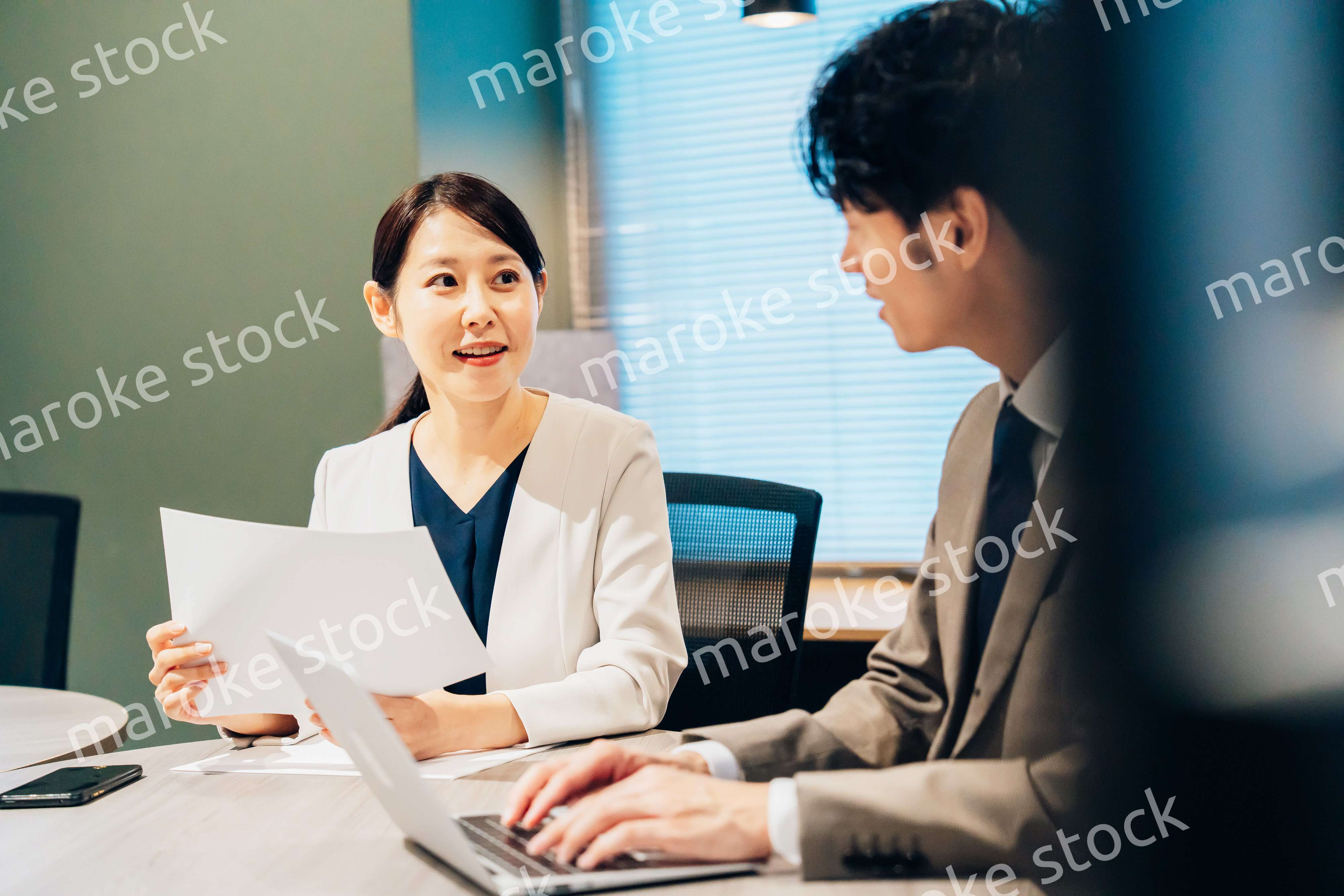 オフィスで打ち合わせをするミドルの女性