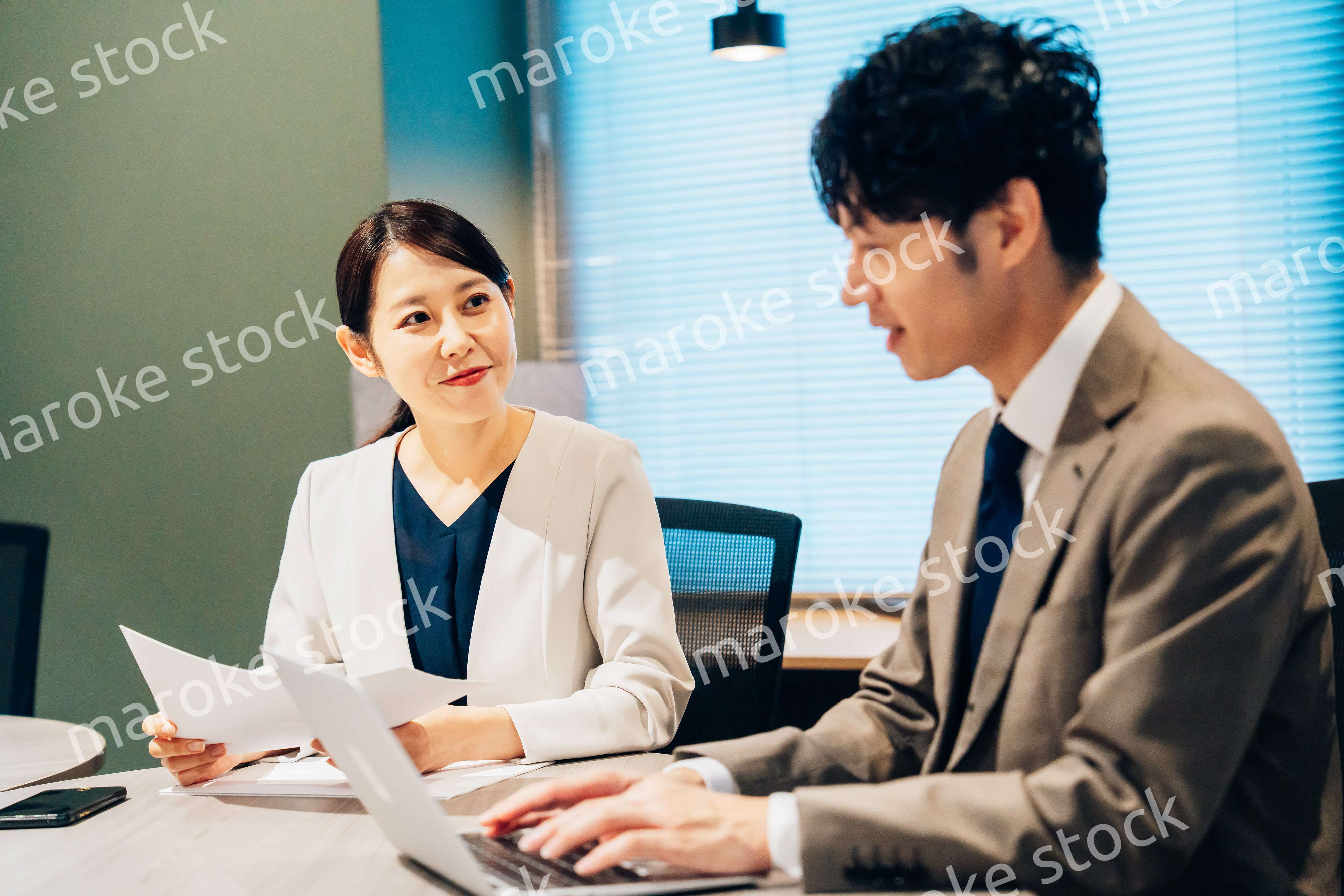 オフィスで打ち合わせをするミドルの女性