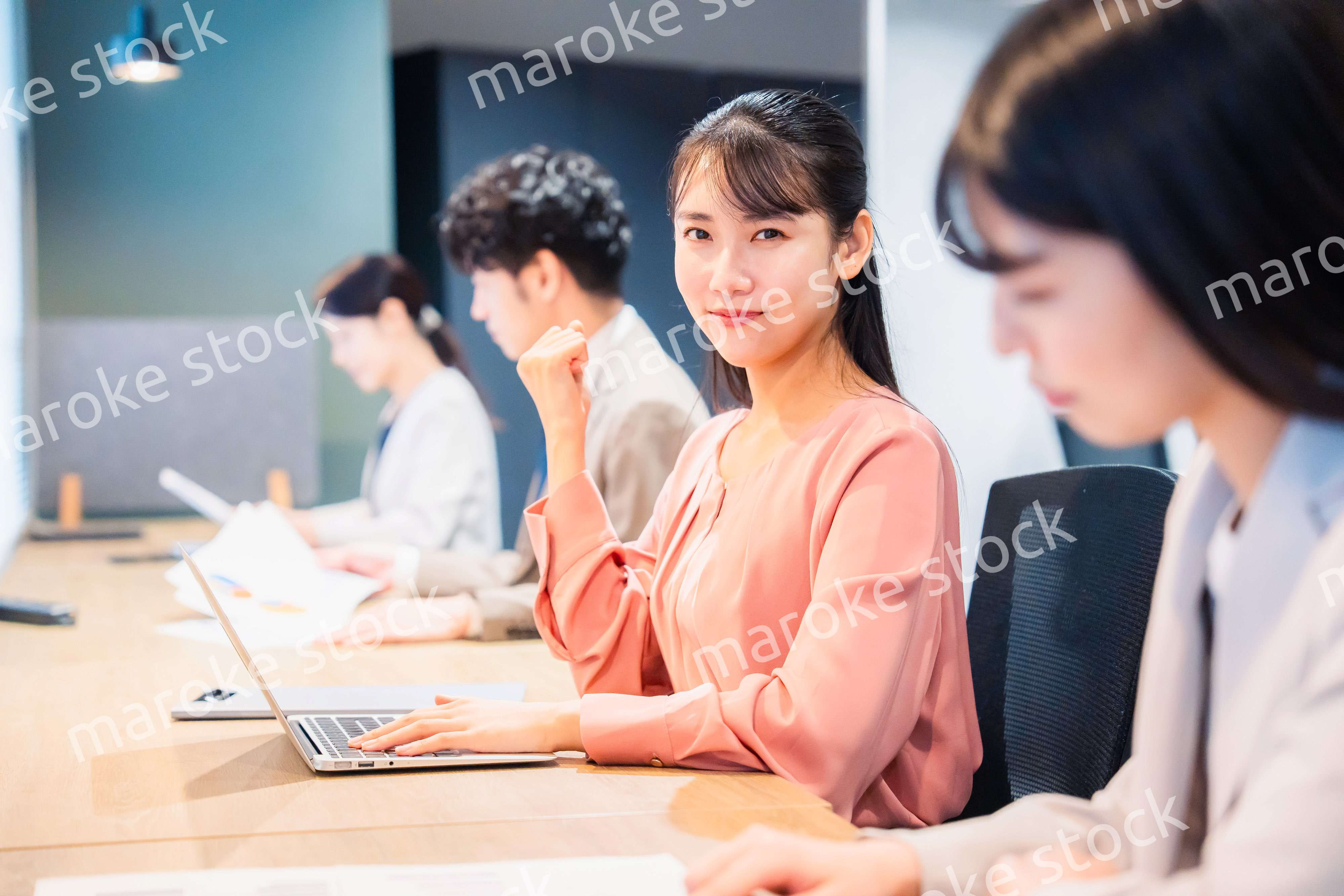 オフィスでガッツポーズをする女性ビジネスパーソン