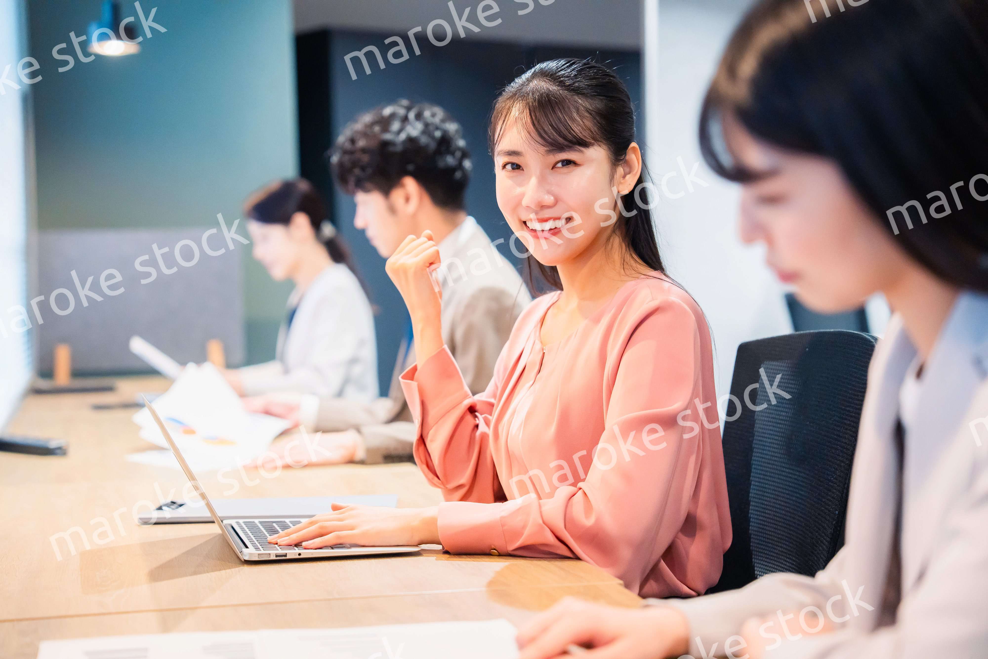 オフィスでガッツポーズをする女性ビジネスパーソン