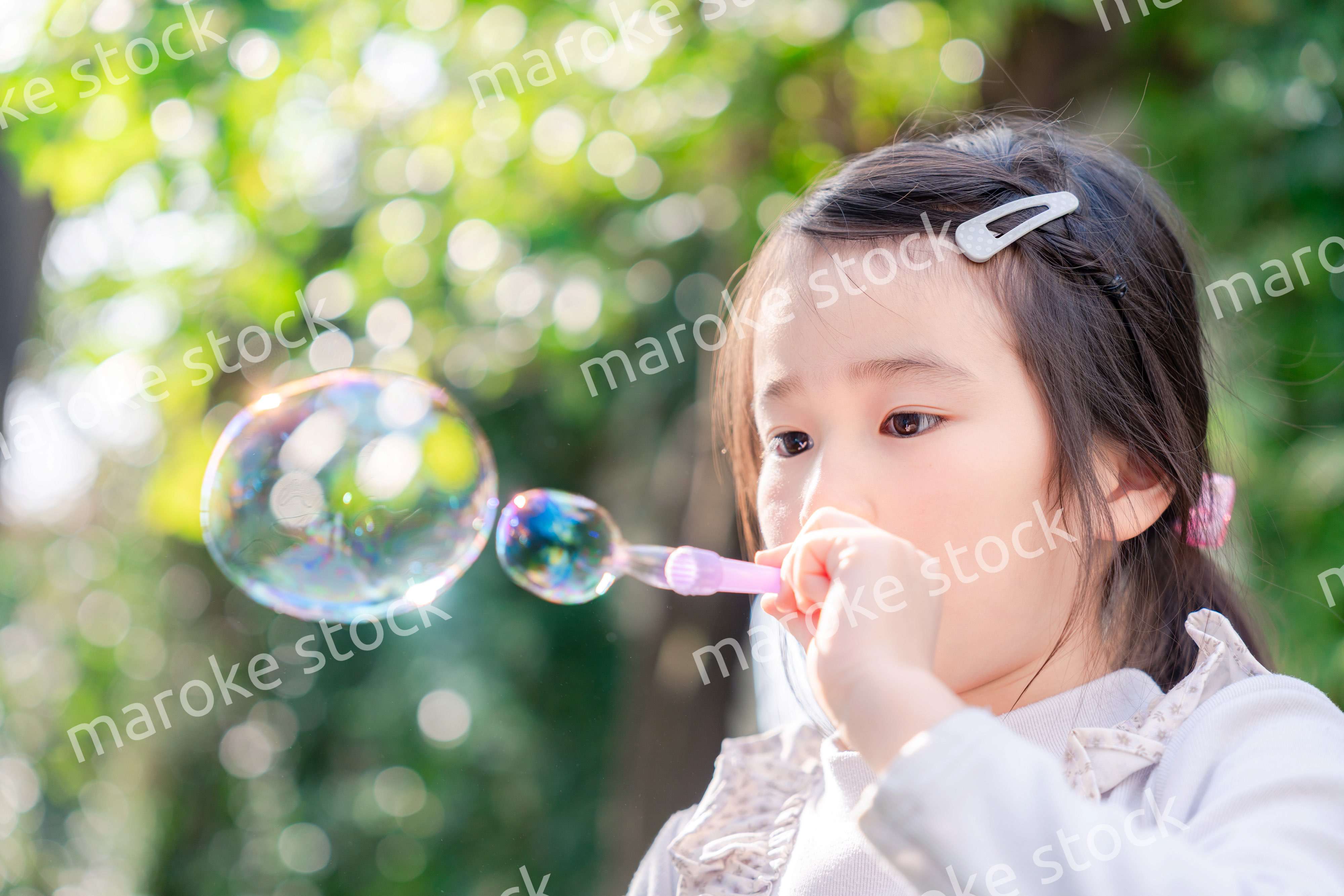 シャボン玉をして遊ぶ小さな女の子