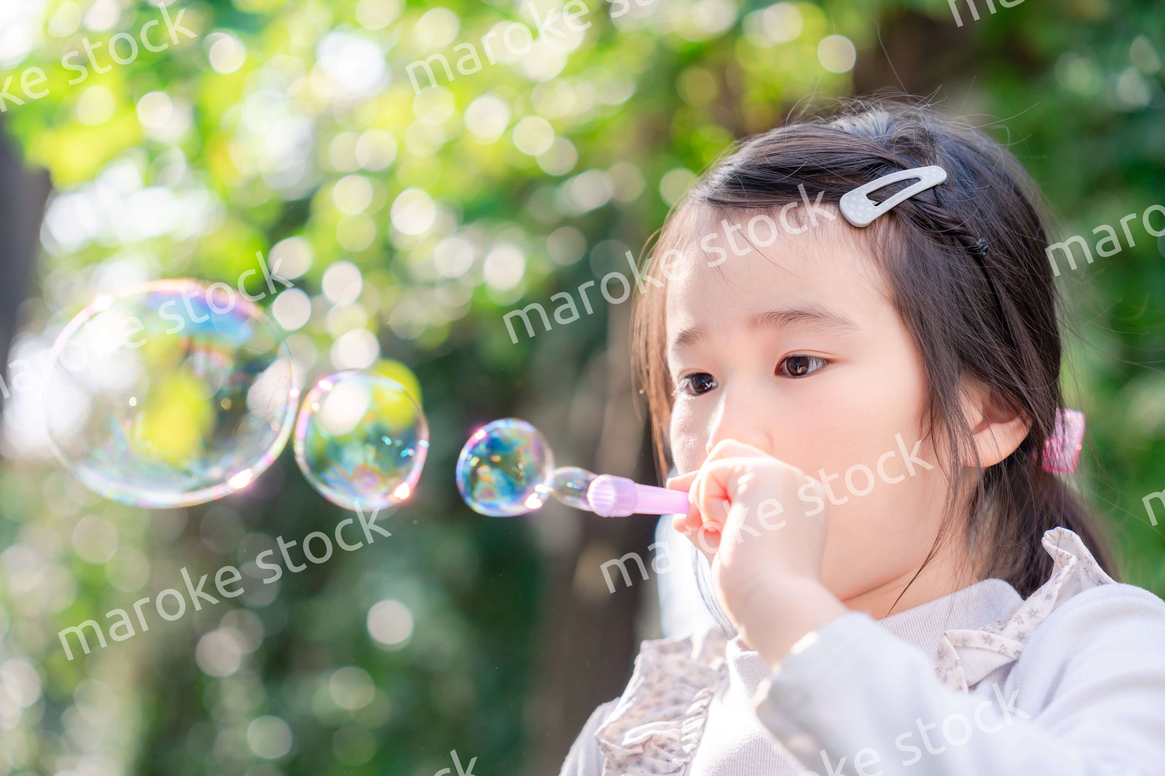 シャボン玉をして遊ぶ小さな女の子