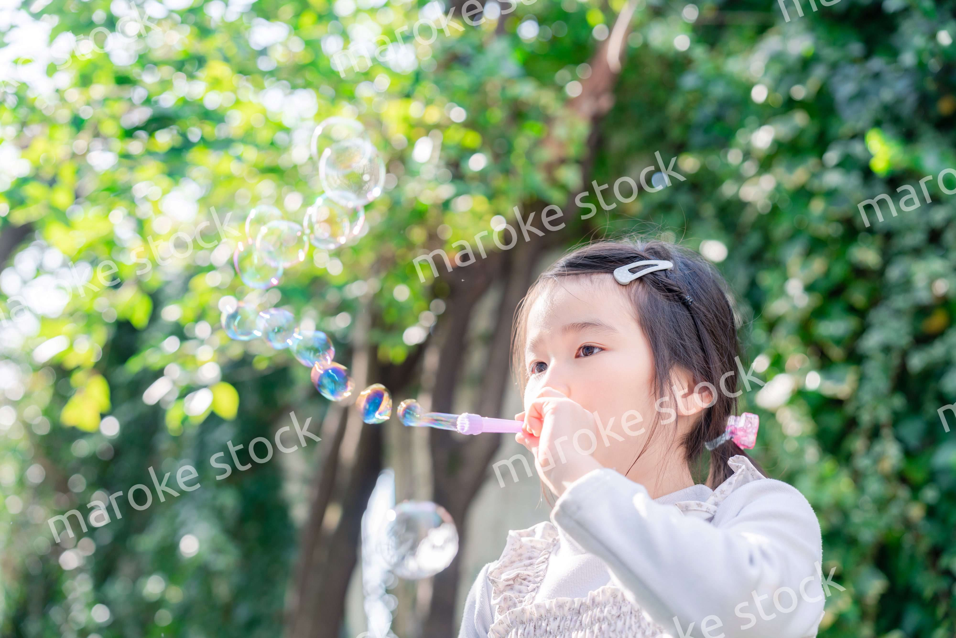 シャボン玉をして遊ぶ小さな女の子