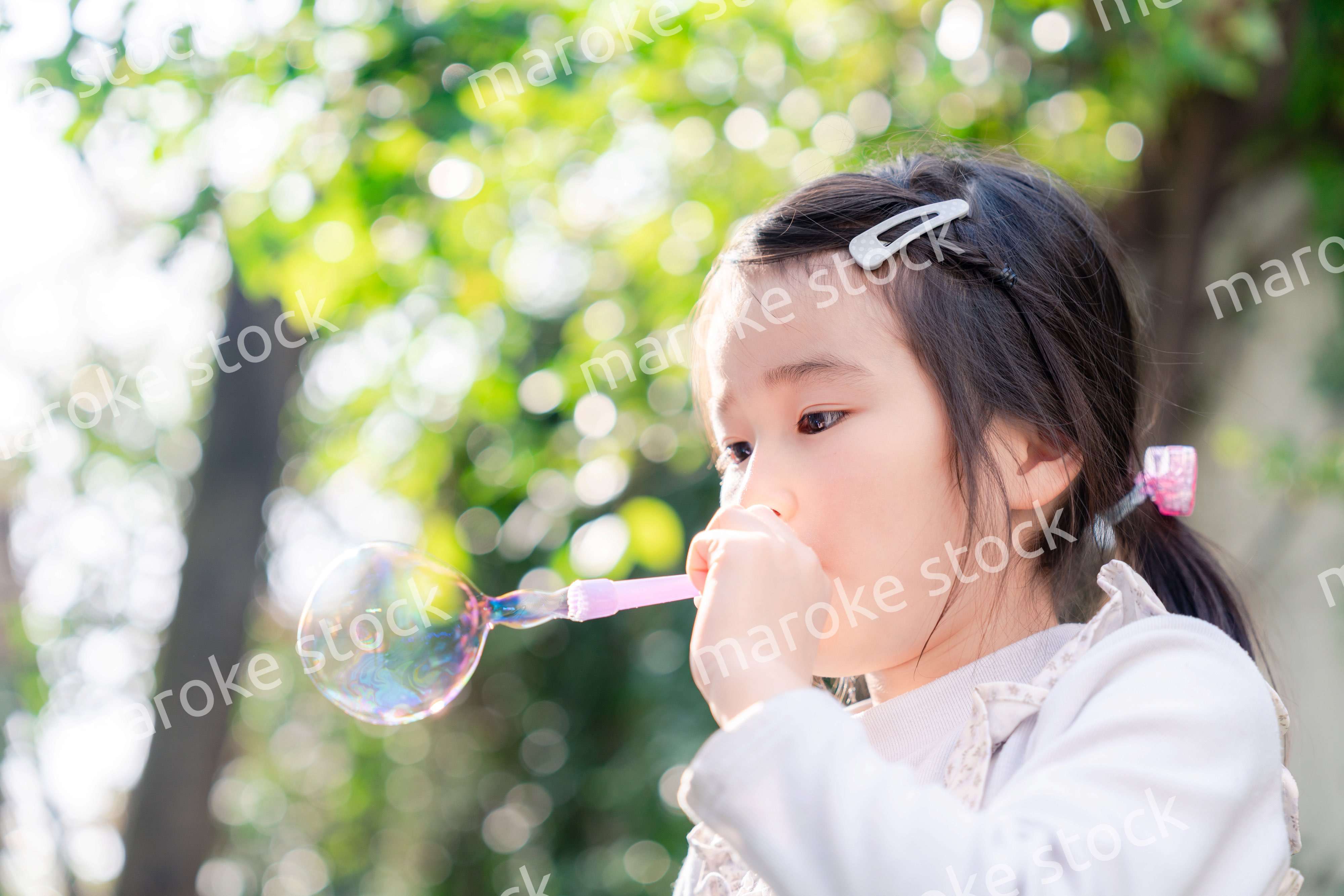 シャボン玉をして遊ぶ小さな女の子