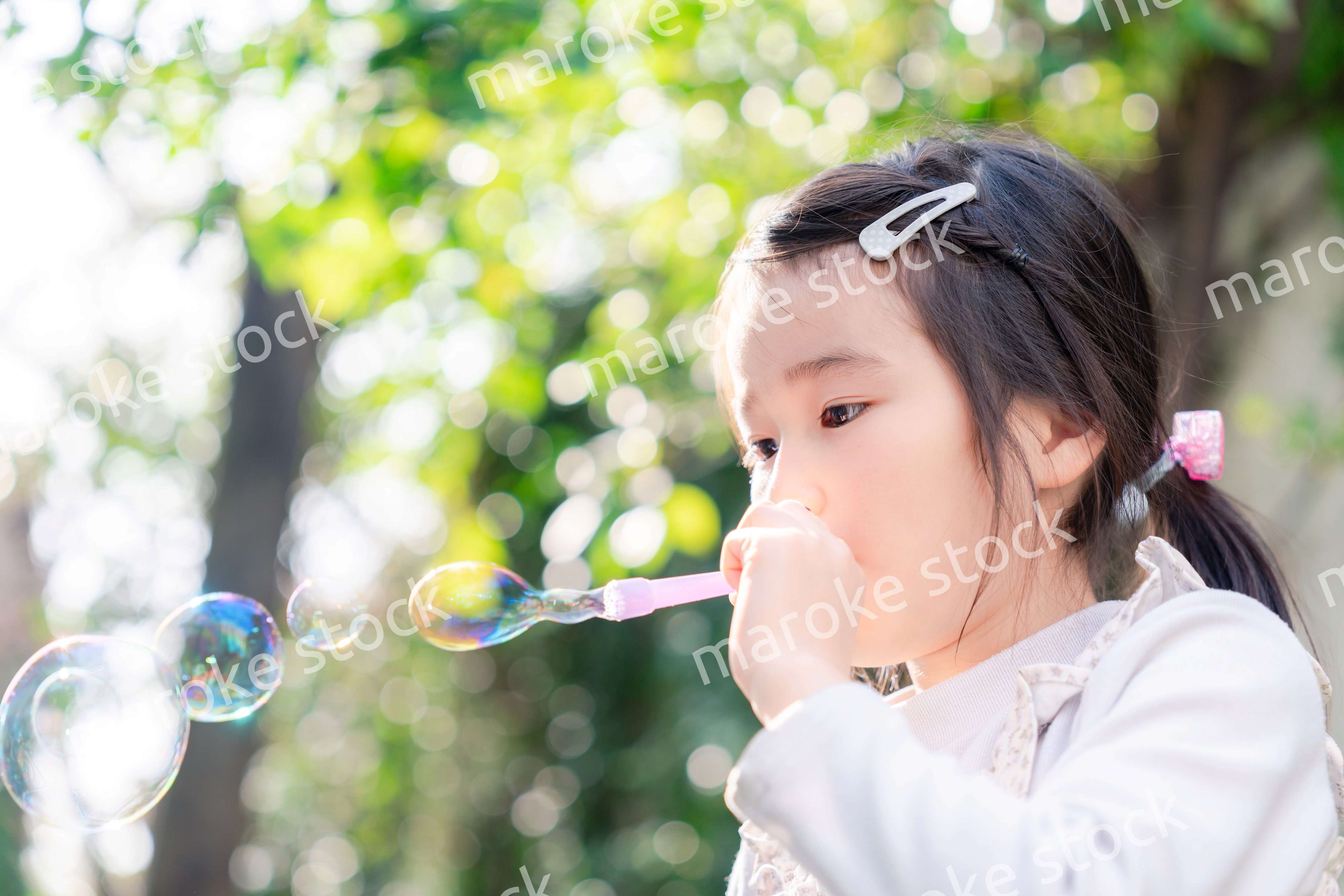 シャボン玉をして遊ぶ小さな女の子