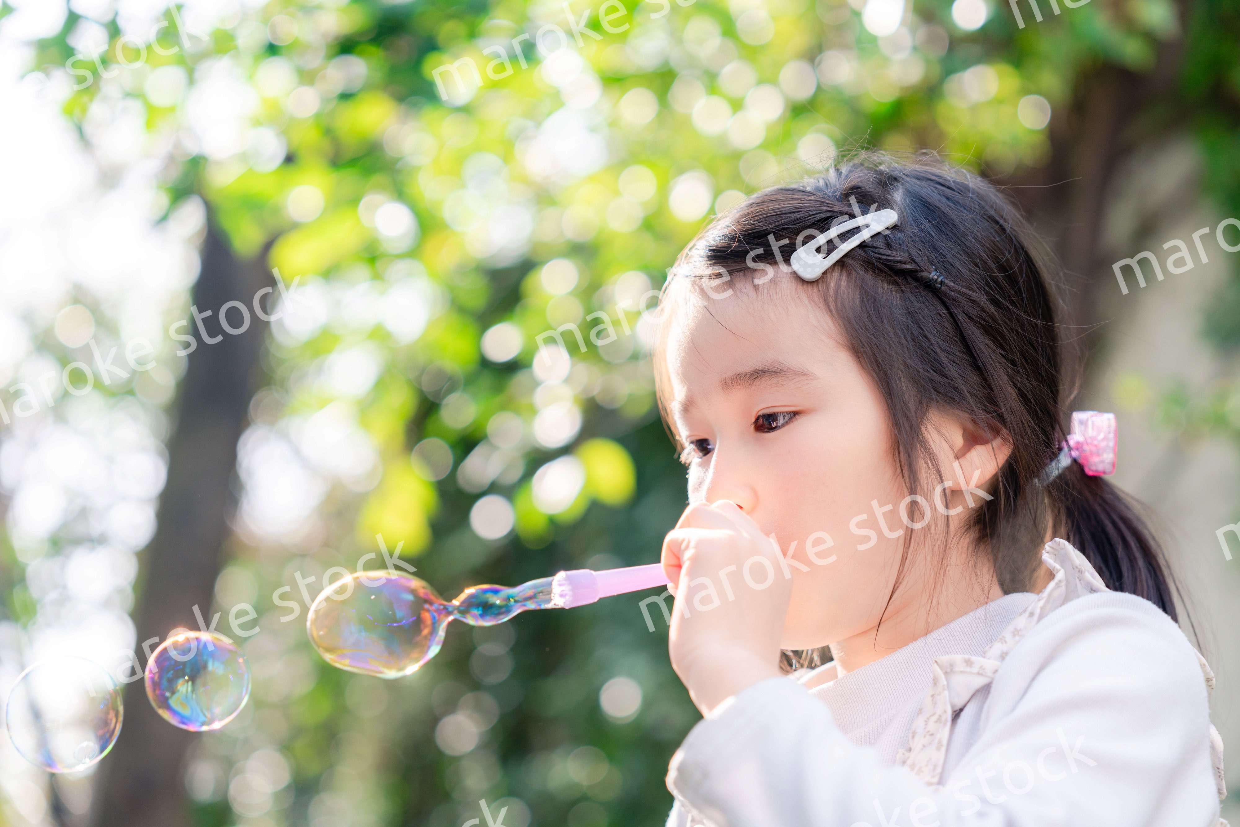 シャボン玉をして遊ぶ小さな女の子