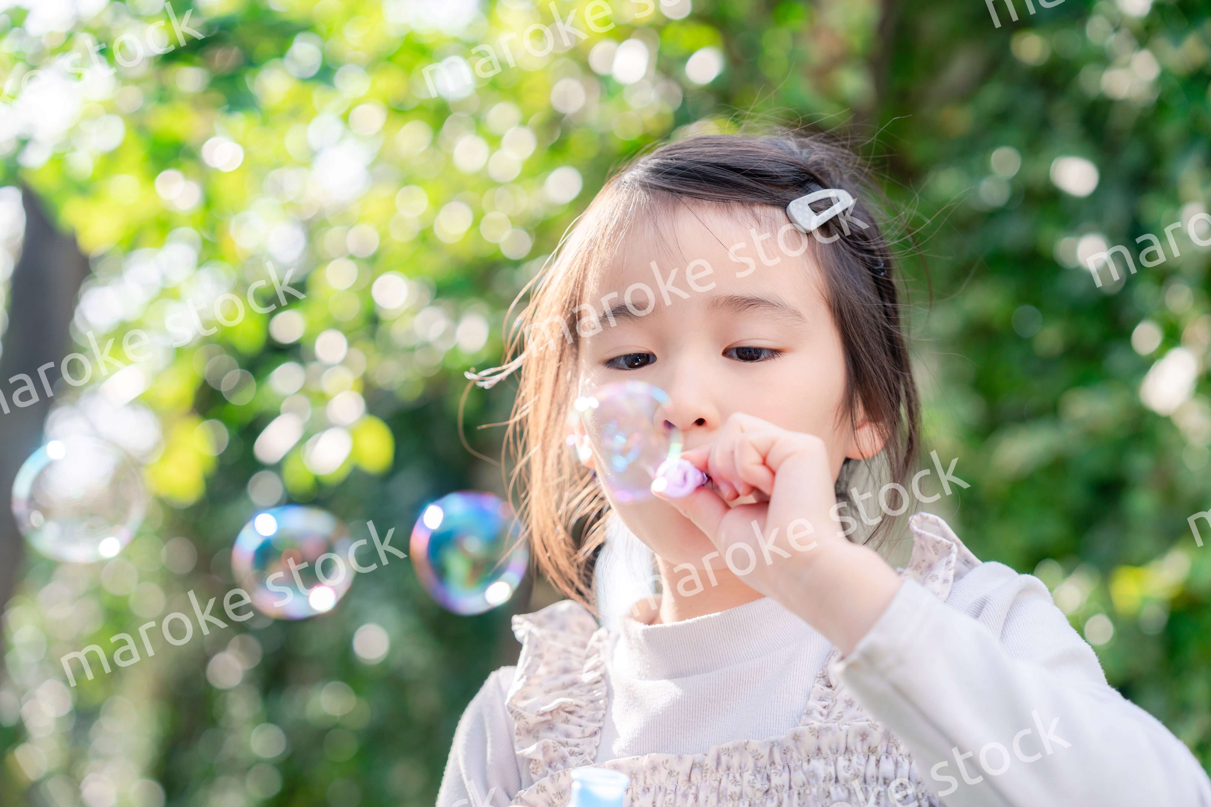 シャボン玉をして遊ぶ小さな女の子