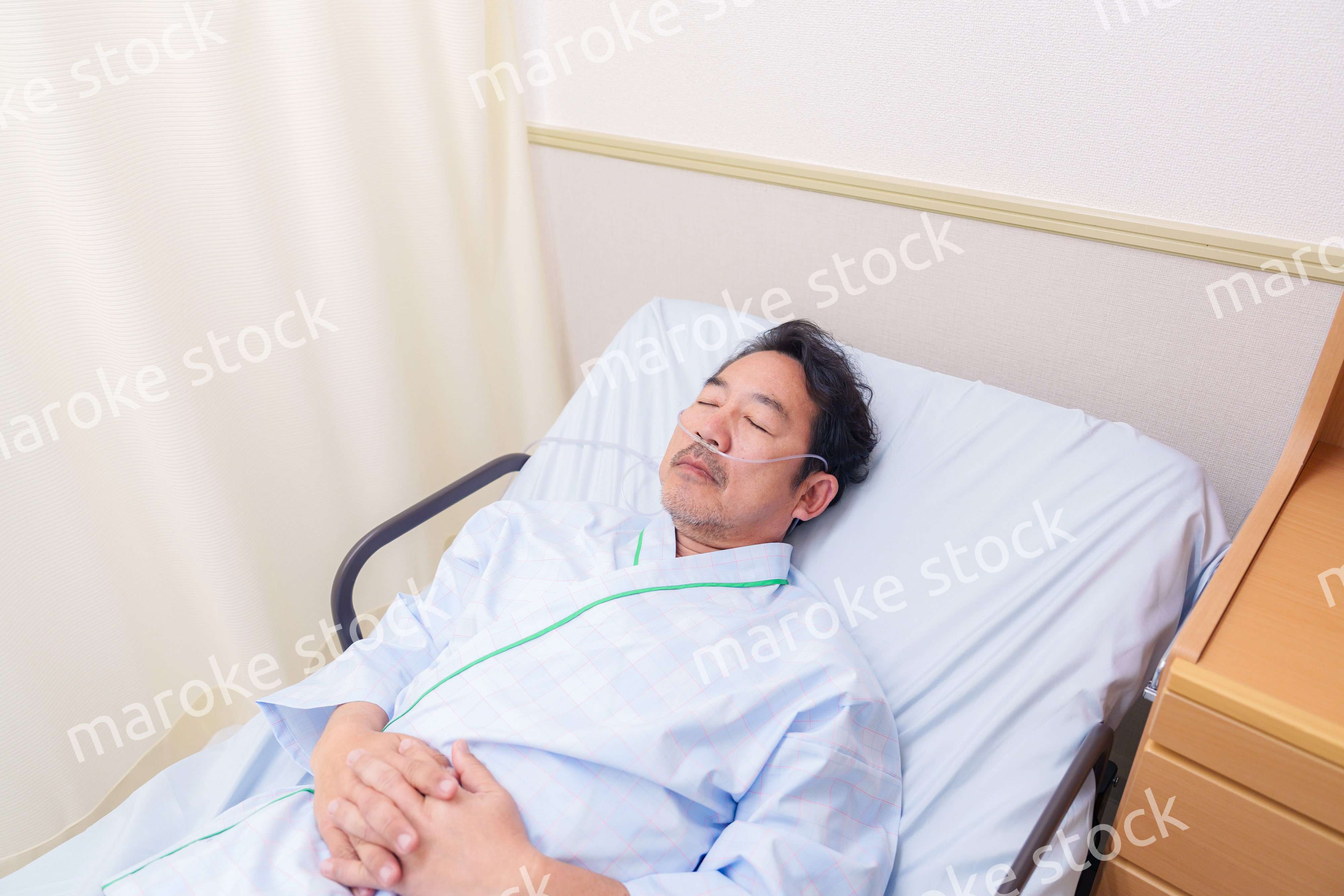 鼻にチューブを装着した入院患者の高齢男性