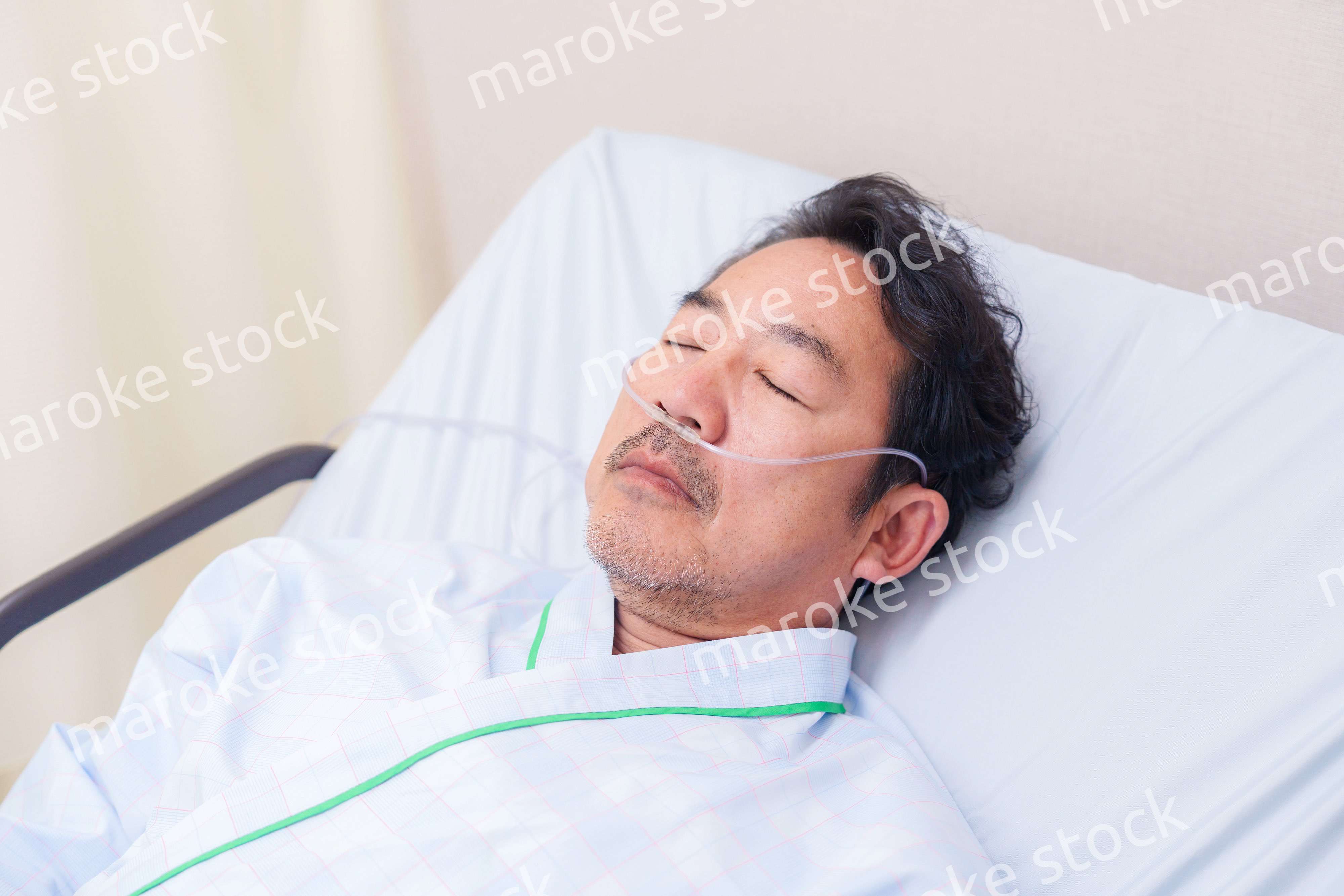 鼻にチューブを装着した入院患者の高齢男性