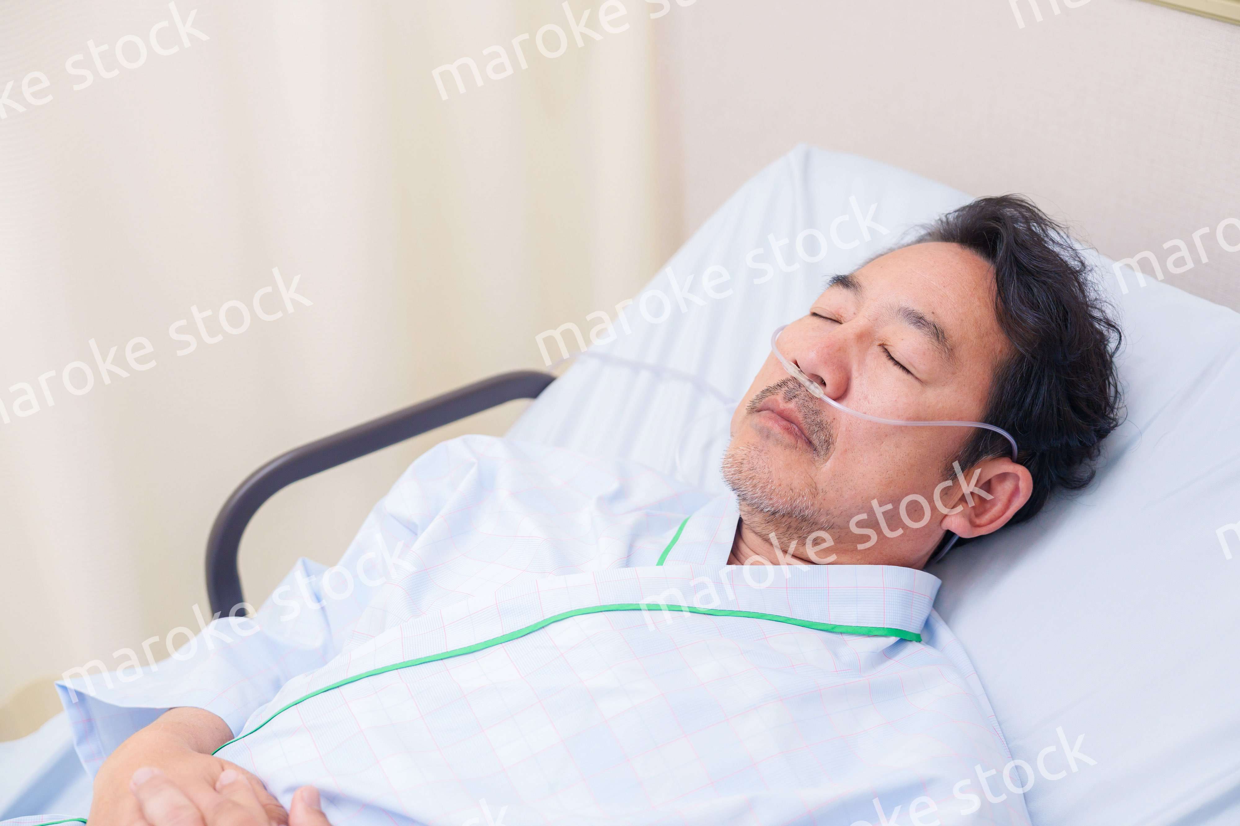 鼻にチューブを装着した入院患者の高齢男性