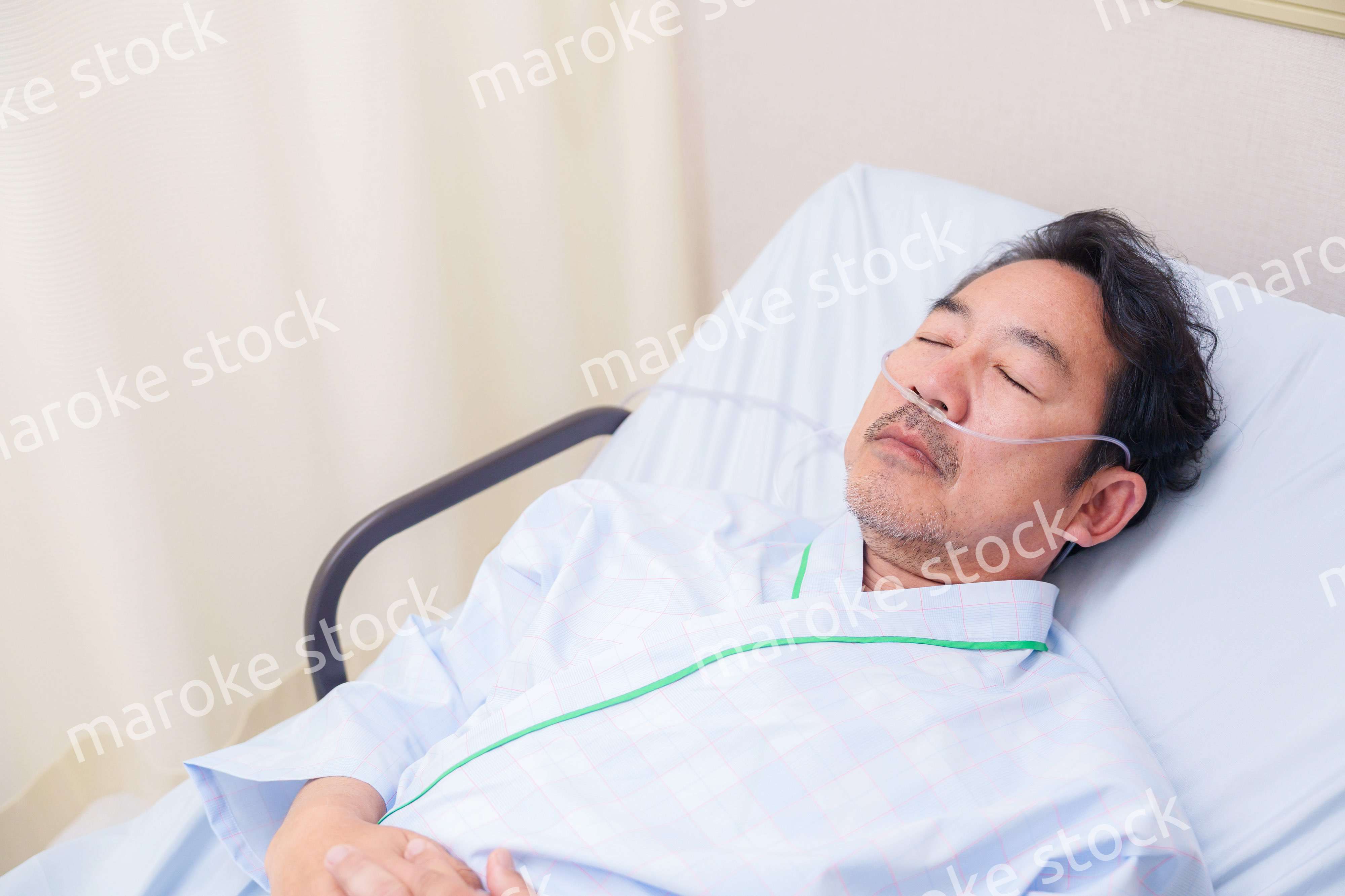 鼻にチューブを装着した入院患者の高齢男性