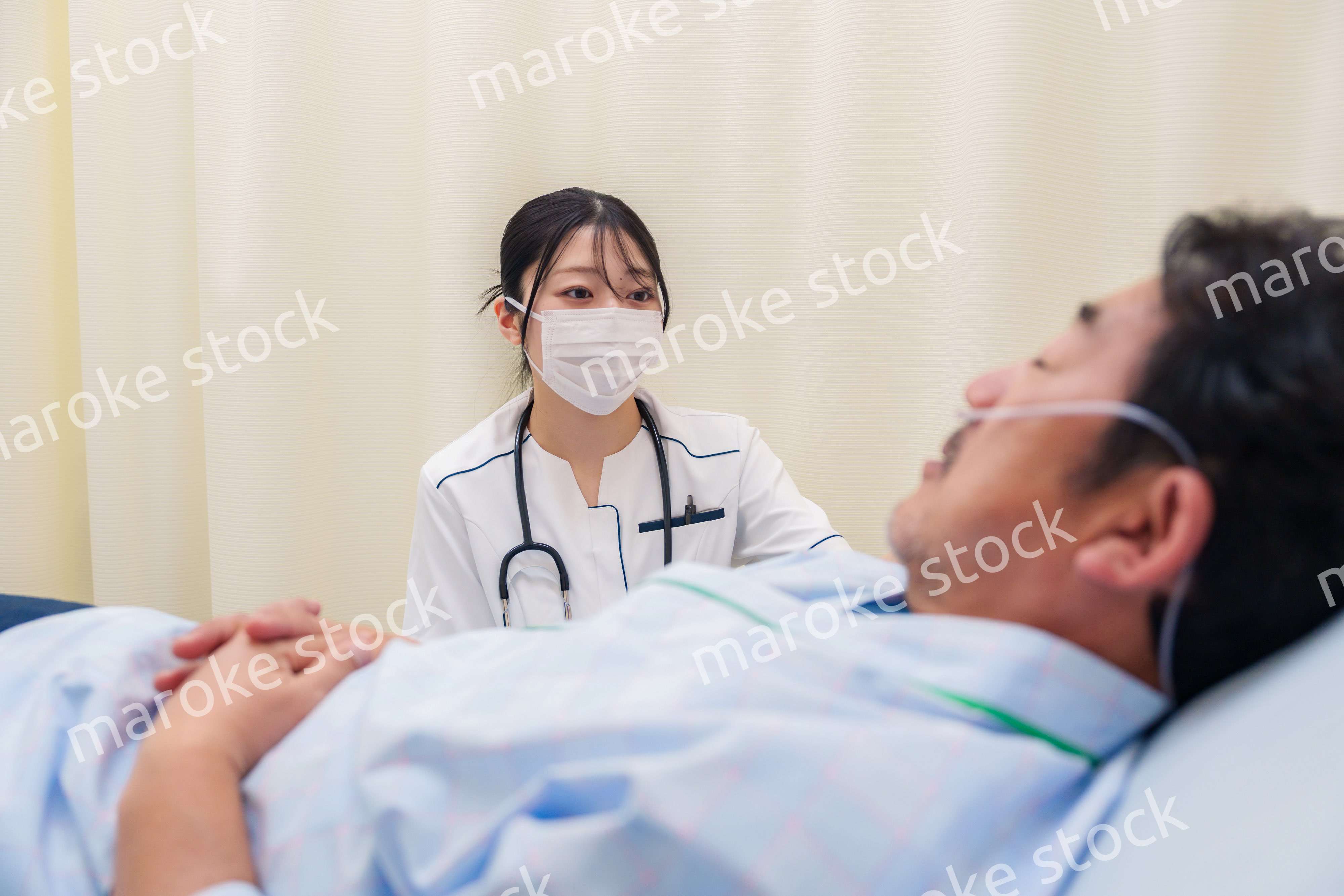 病棟で入院患者のケアをする医療従事者の女性